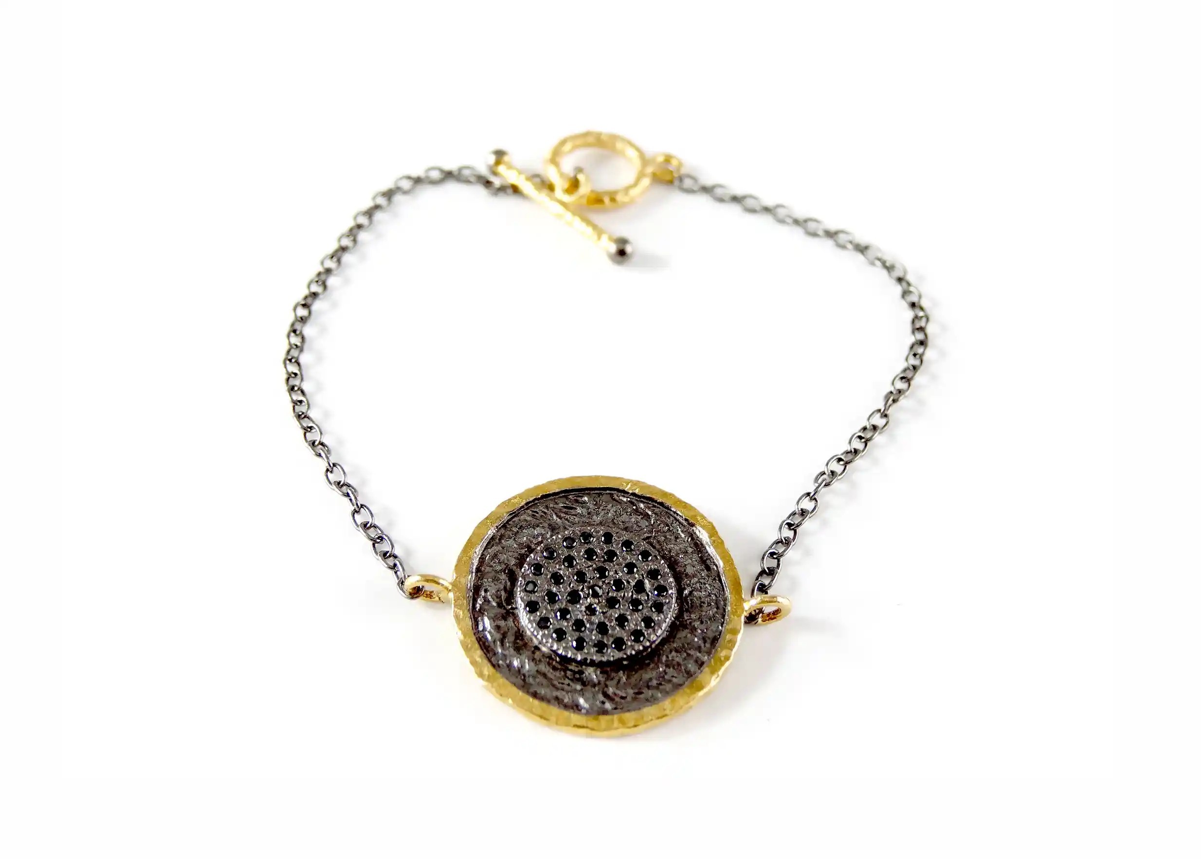 Brass bracelet from the Nuit des Temps collection with T-bar clasp, photo taken against a white background
