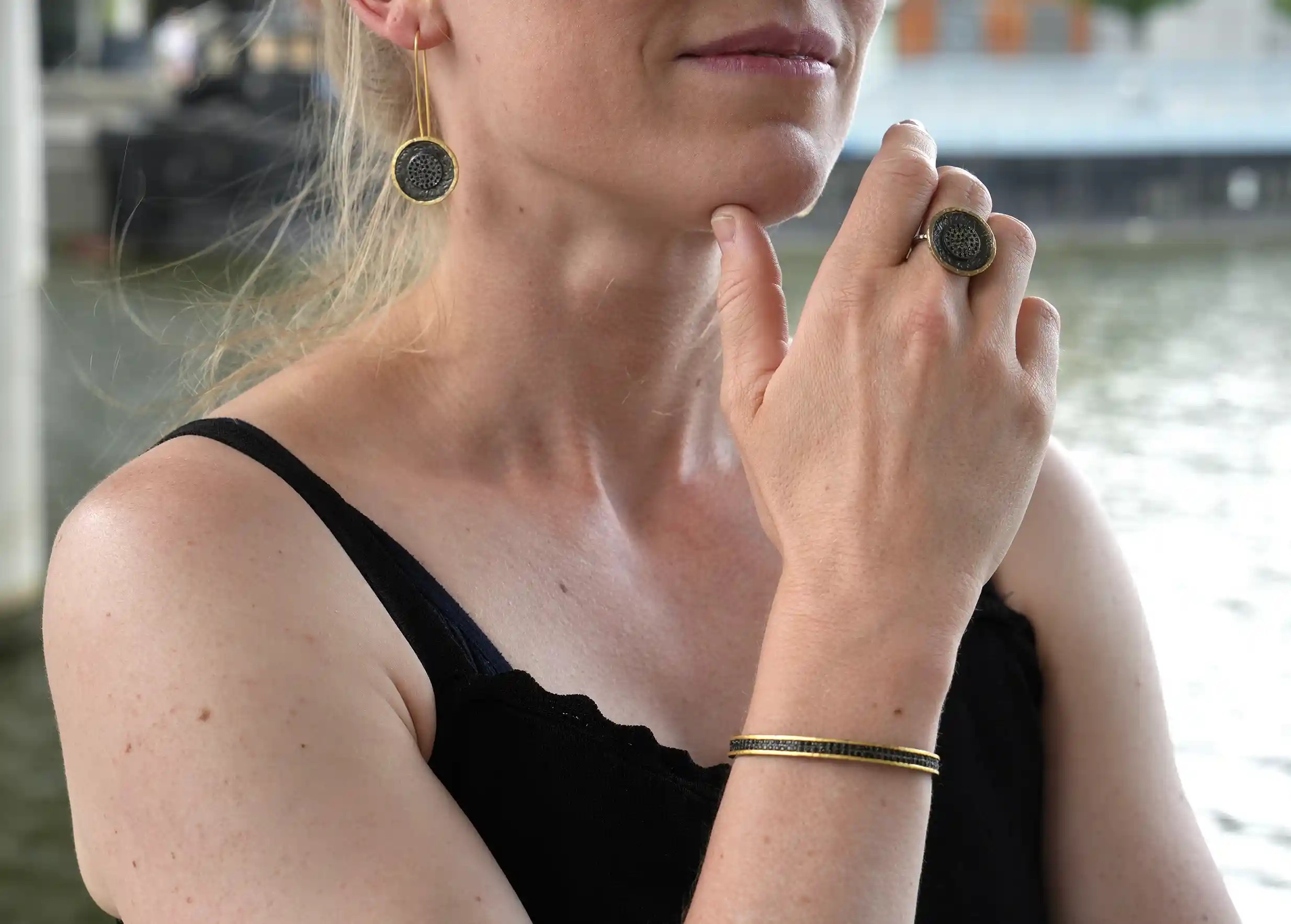 Woman wearing an adjustable bracelet made of brass, oxidised brass and zirconium Dawn of Time