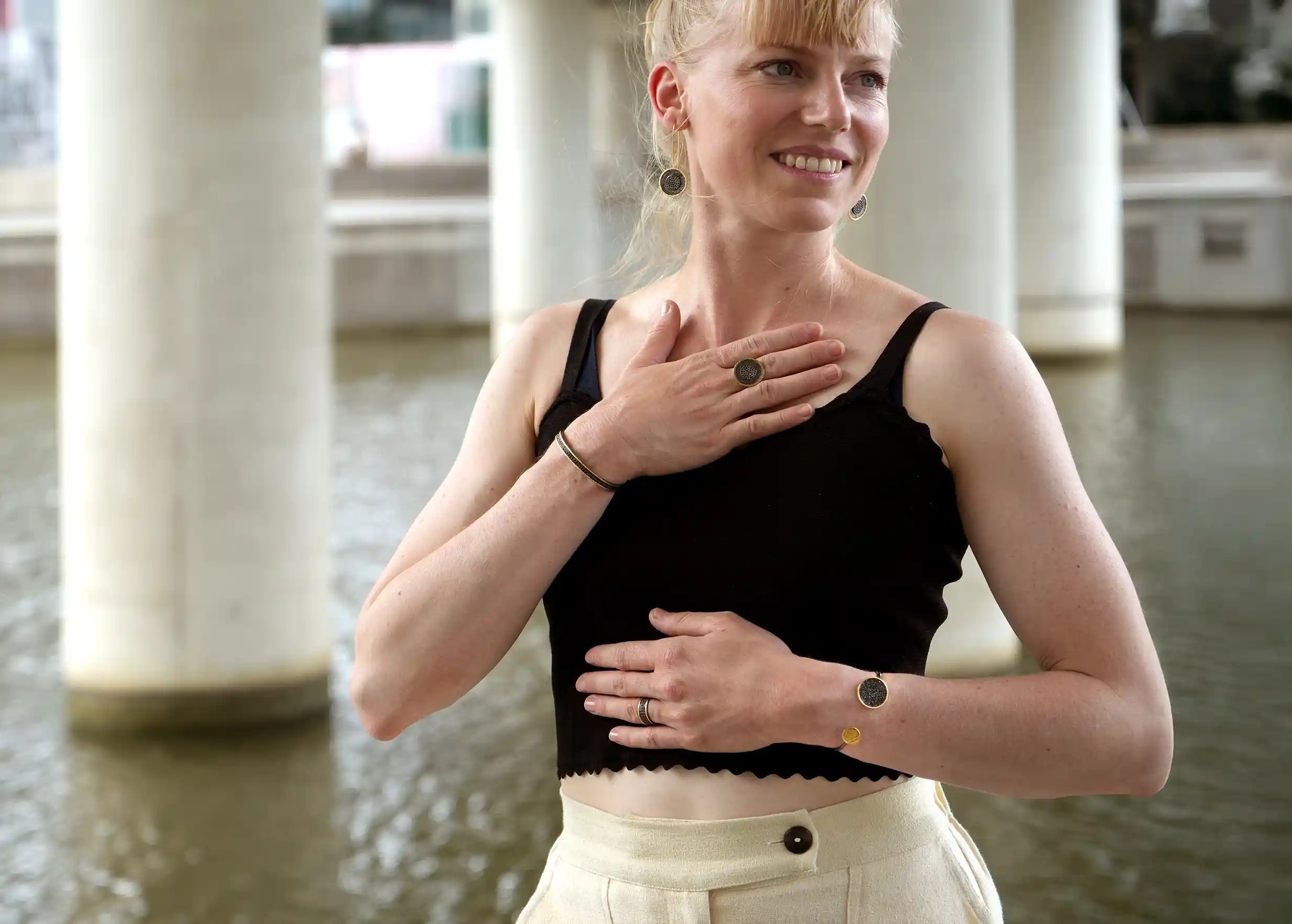 Handcrafted brass and zirconium bangle bracelet from the Dawn of Time collection worn by a woman around her wrist