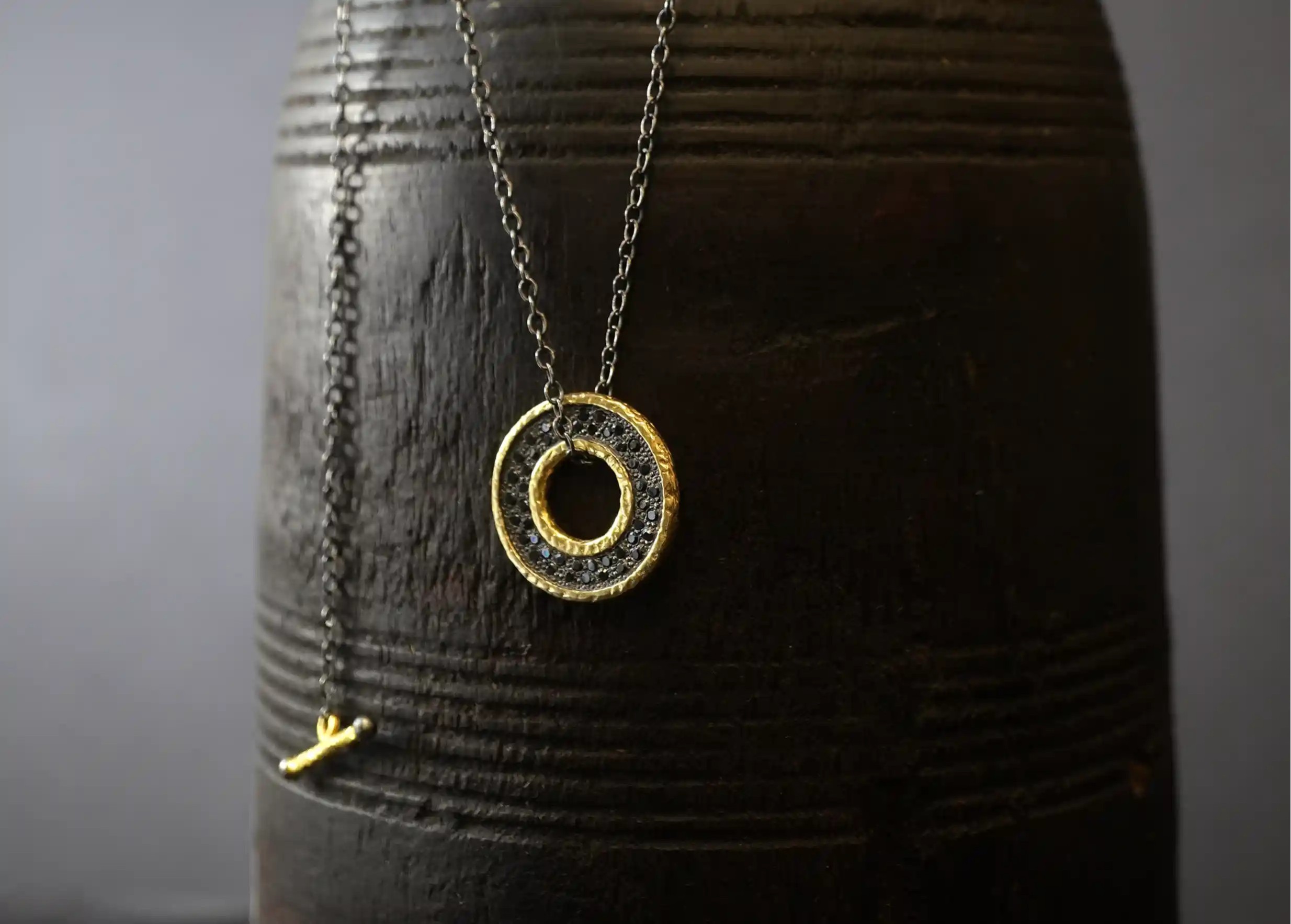 Gilded-plated brass medallion necklace with chain and black zirconium inlays, suspended