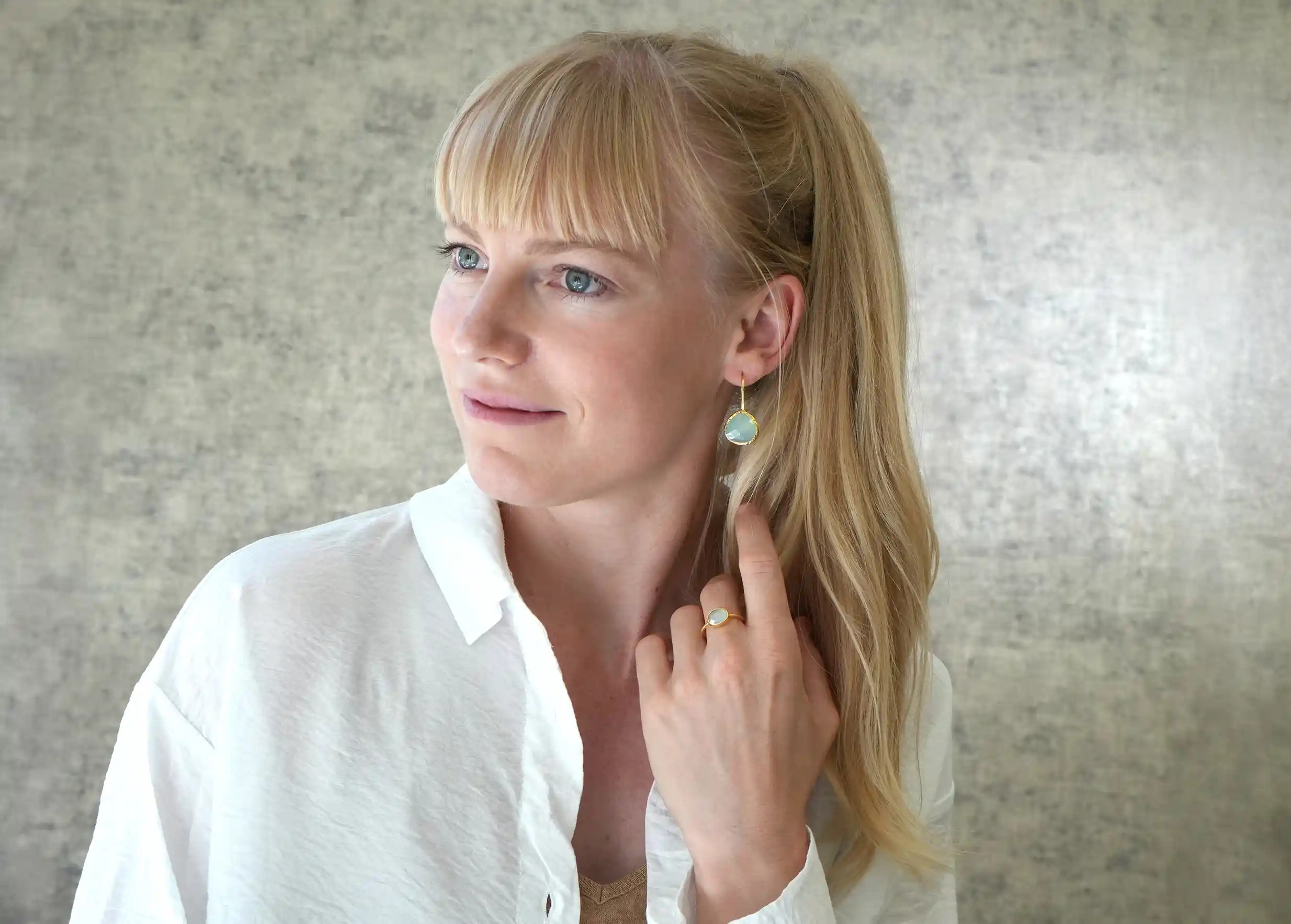 Gold-plated Drop ring, chalcedony worn by a smiling woman indoors