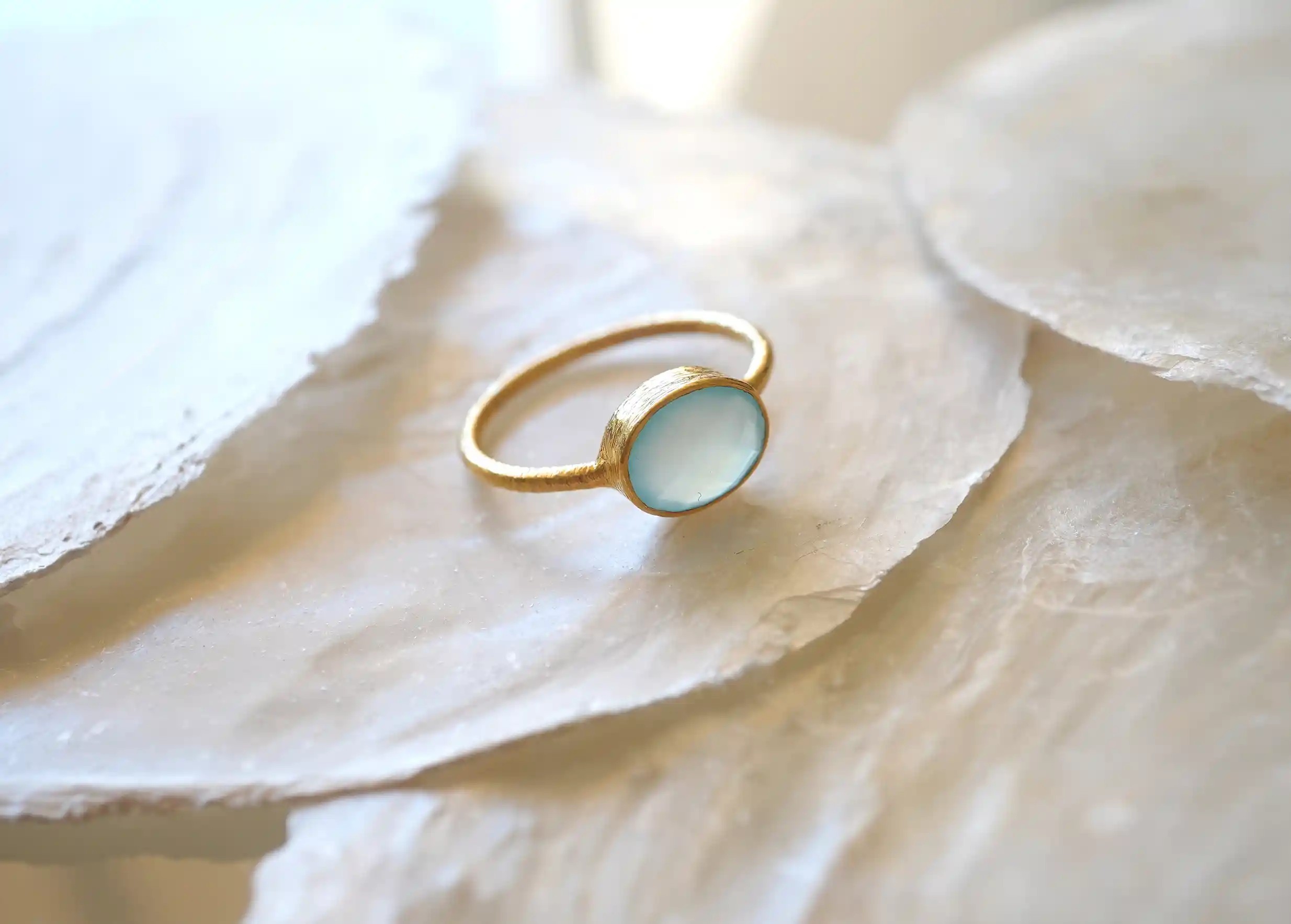 Gold-plated ring from the Yamuna collection, displayed on a stone