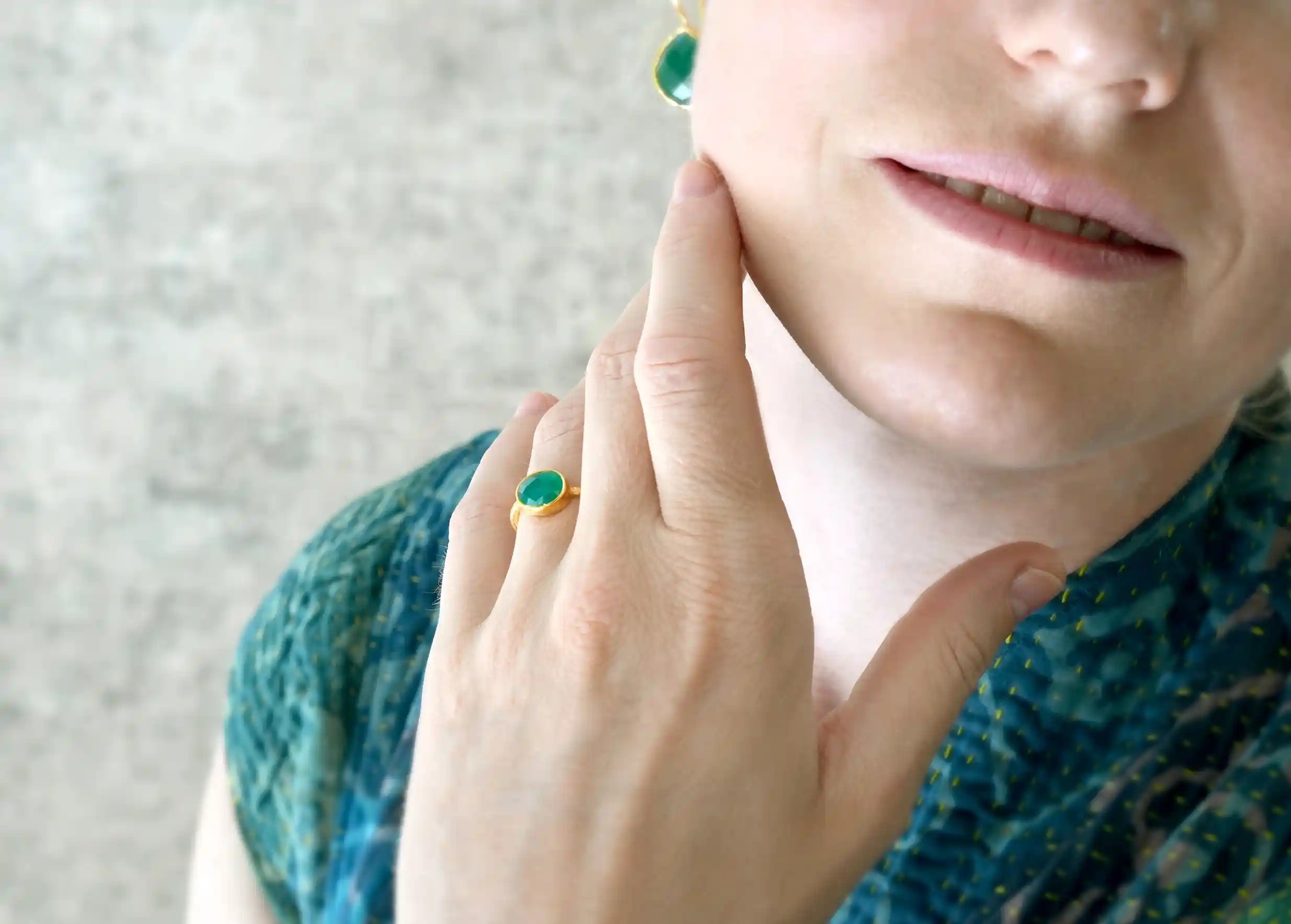 Bague plaqué or Drop, Onyx vert porté par une femme en intérieur