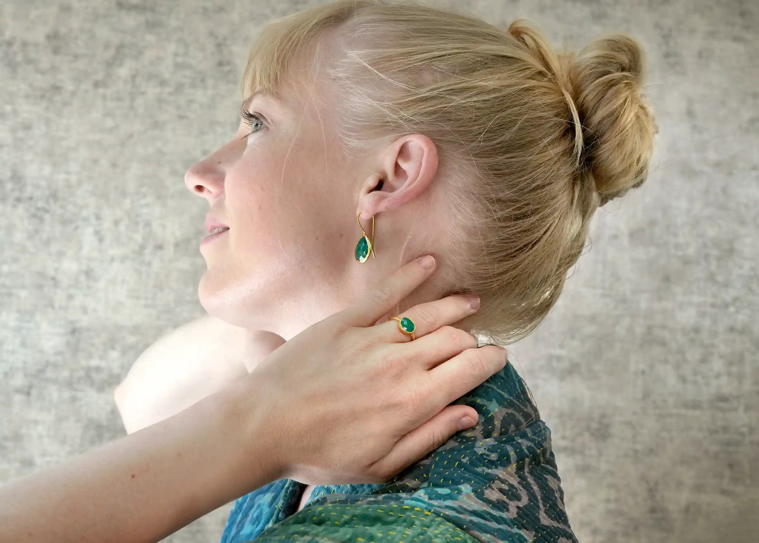 Femme souriante de profil portant une bague plaqué or Drop, Onyx vert