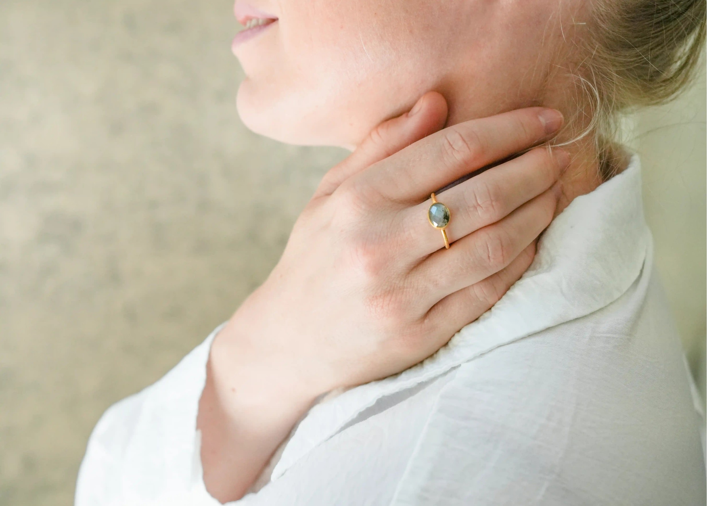 Gold and labradorite ‘Drop’ ring, worn by a woman indoors