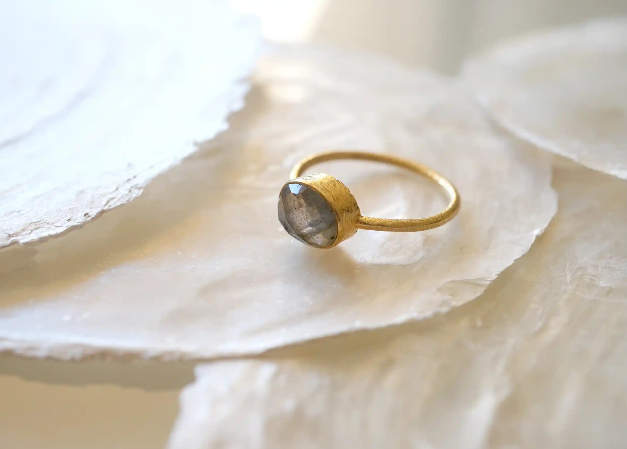 Gold-plated Drop ring, Labradorite on the ground near a stone