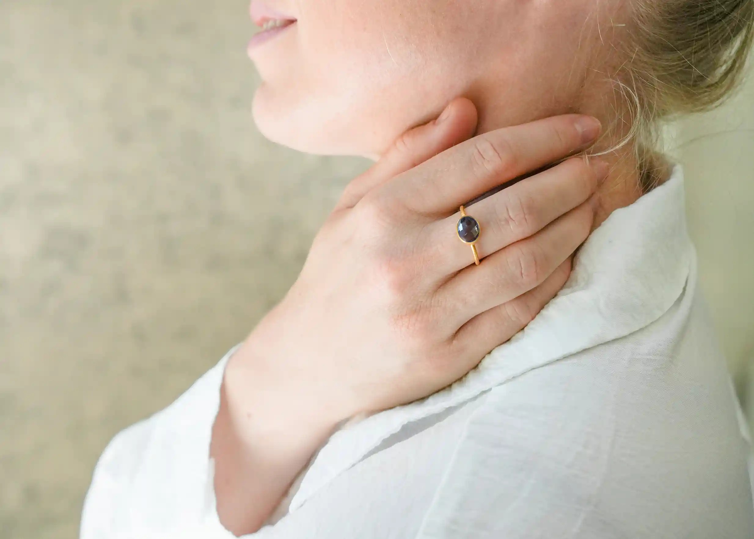 Woman wearing a ‘Drop’ ring in gold and smoky quartz, Yamuna collection