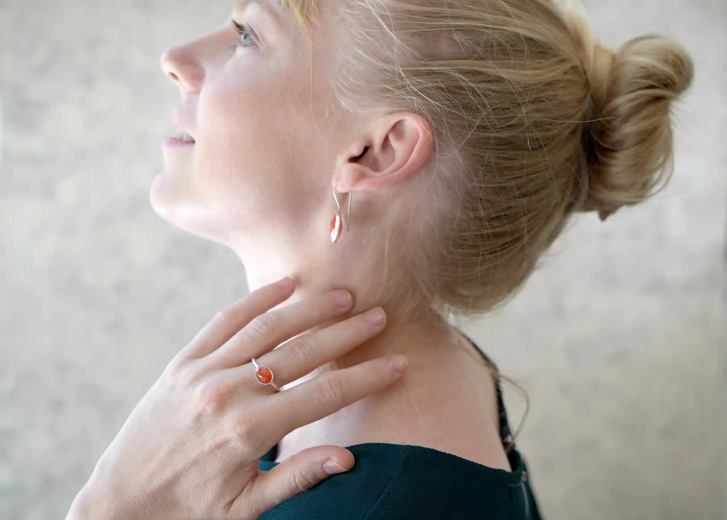 Woman in profile wearing a silver and carnelian ‘Drop’ ring,