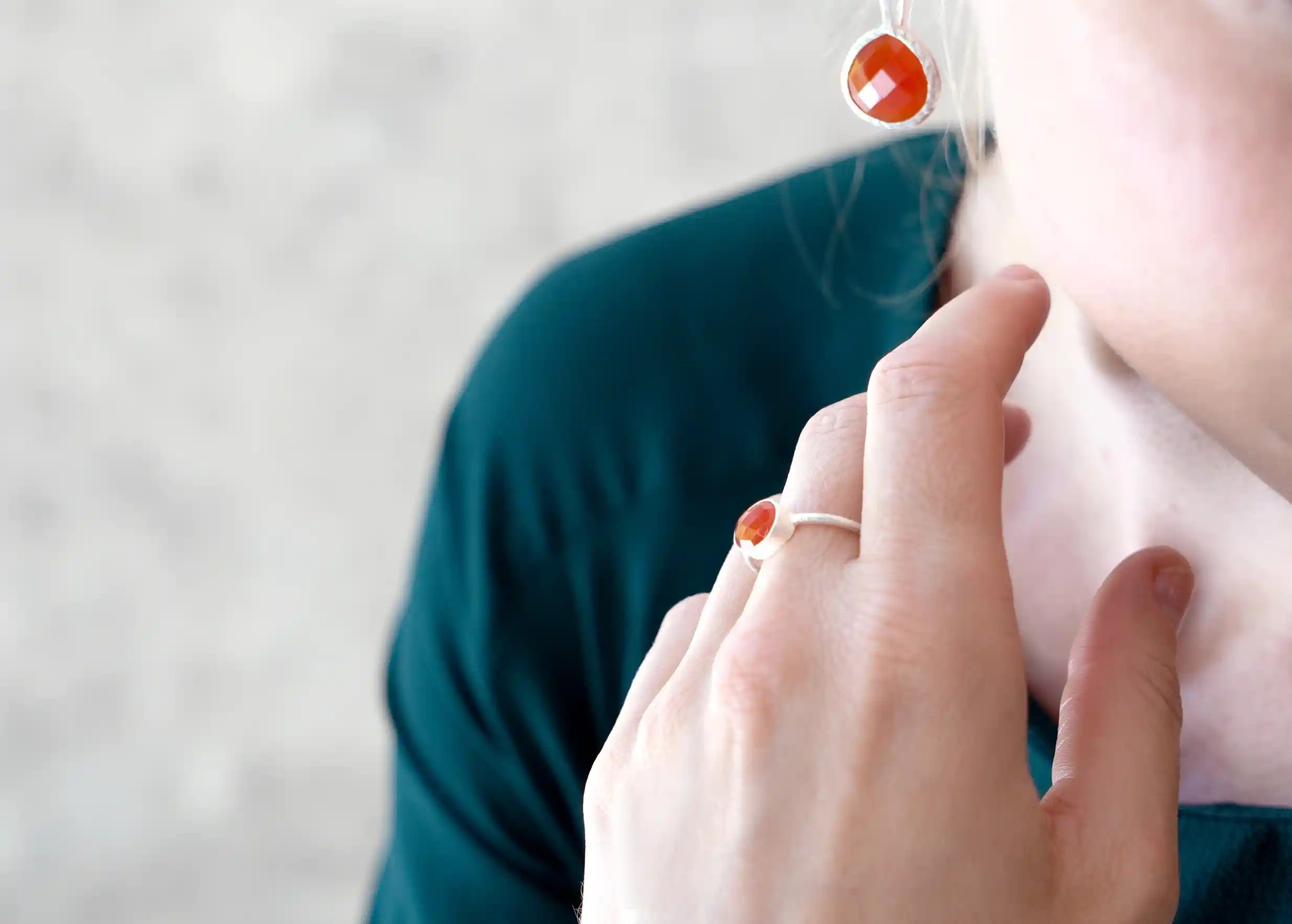Woman's hand wearing a silver and carnelian ‘Drop’ ring, Yamuna collection,