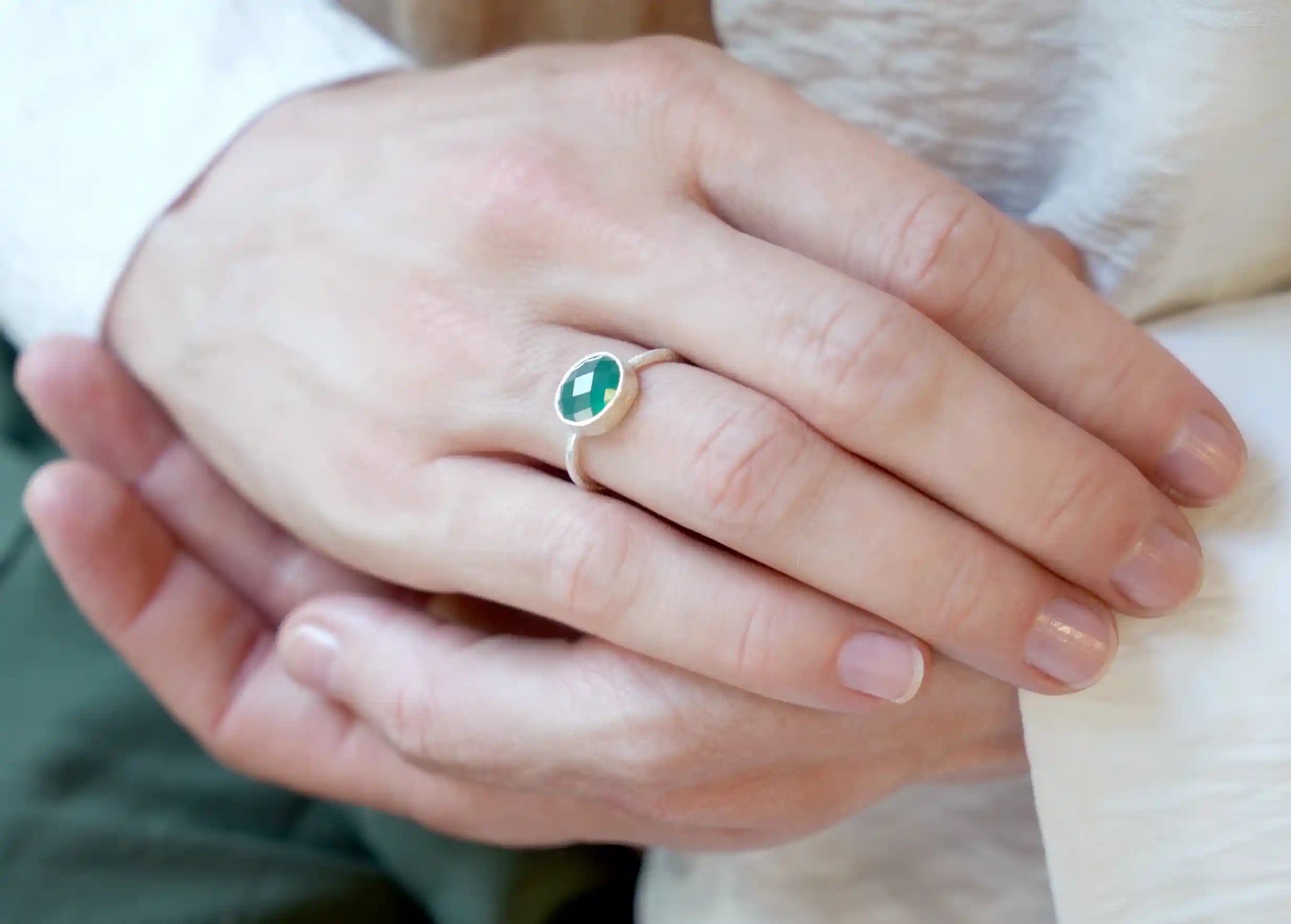 Zoom sur les mains d'une personne portant une bague en argent 925 Drop, pierre vert onyx