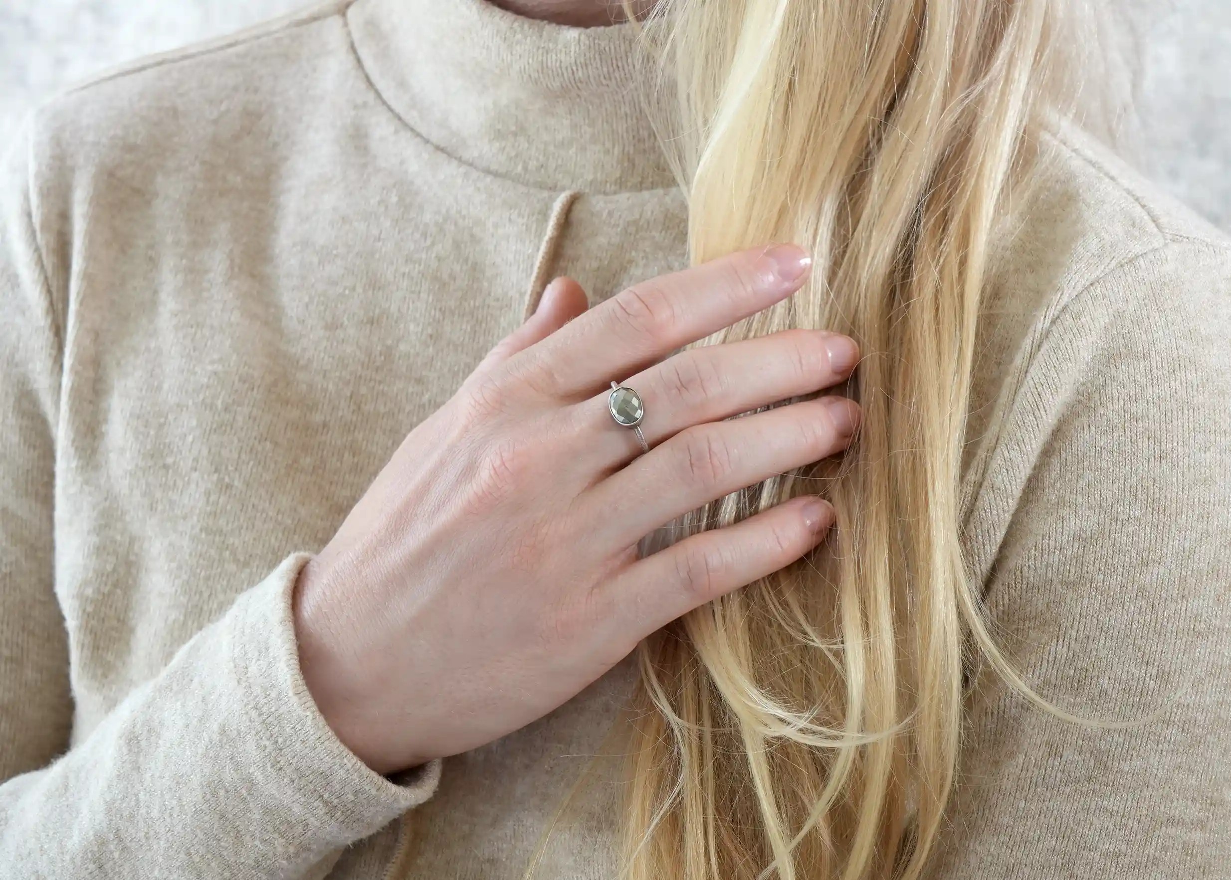 Close-up of a woman's hand wearing a silver and pyrite ‘Drop’ ring from the Karawan Authentic brand.