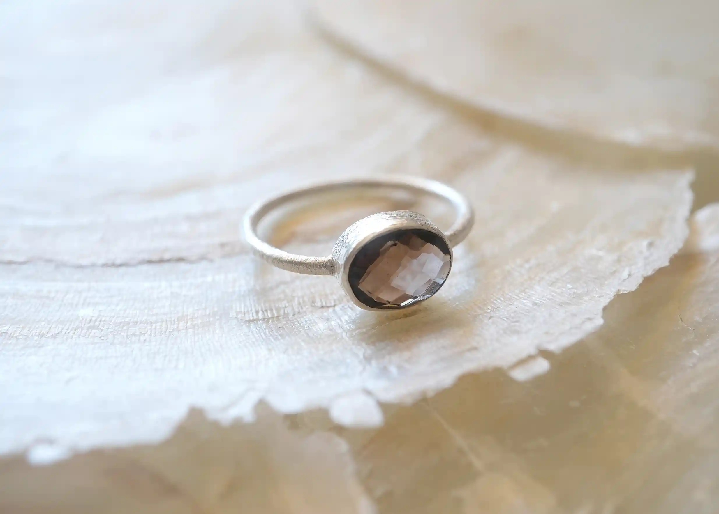 Bague « Drop » argent & pierre quartz fumé, exposés sur une pierre