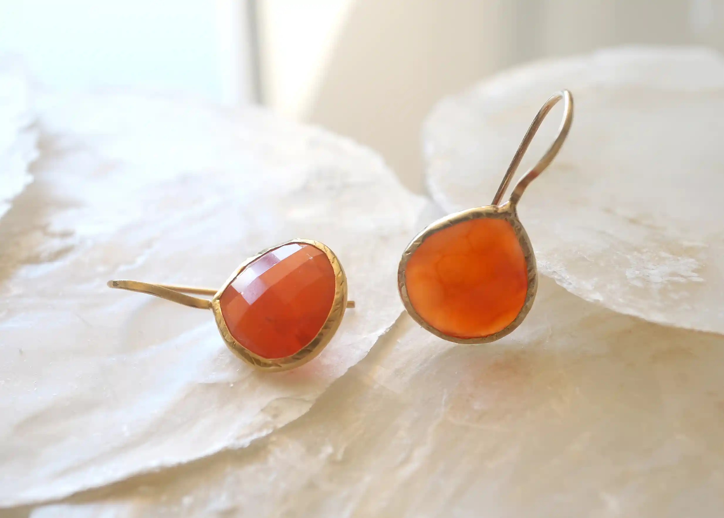 Gold and carnelian drop earrings, Yamuna collection, set on a stone