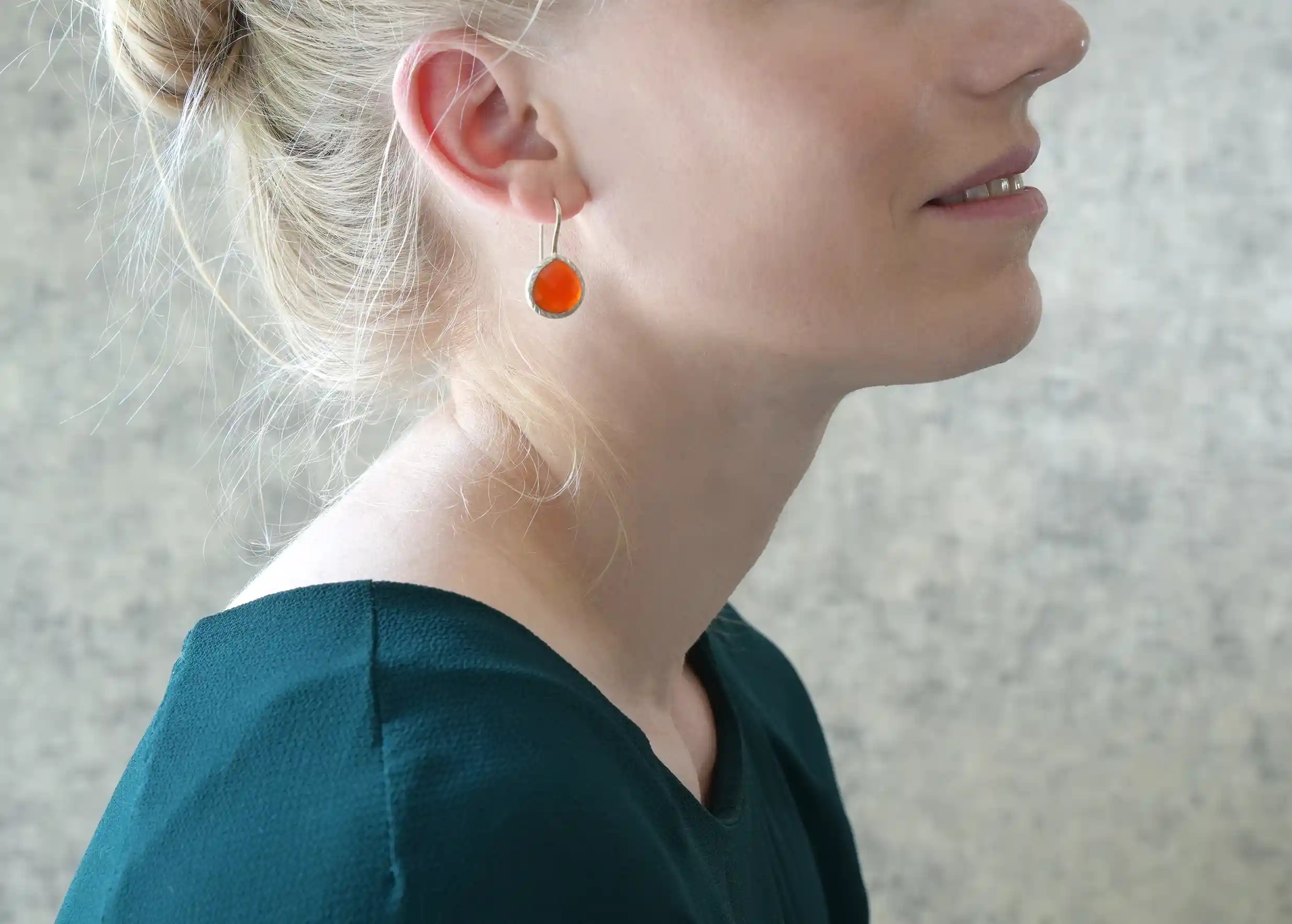 Woman in profile wearing silver and carnelian drop earrings, Yamuna collection