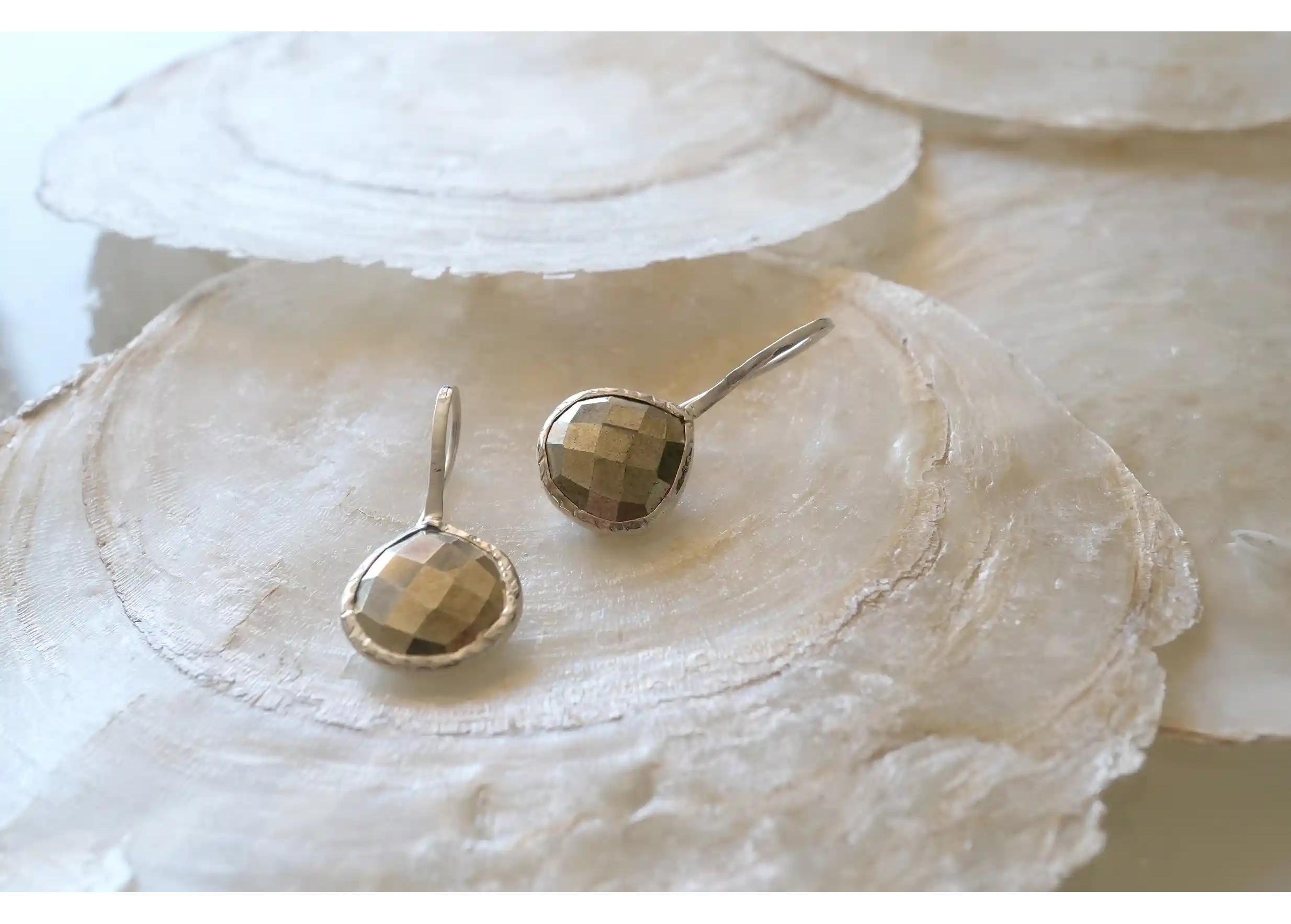 Zoom sur les reflets des boucles d’oreilles « Drop » argent & pierre pyrite, collection Yamuna