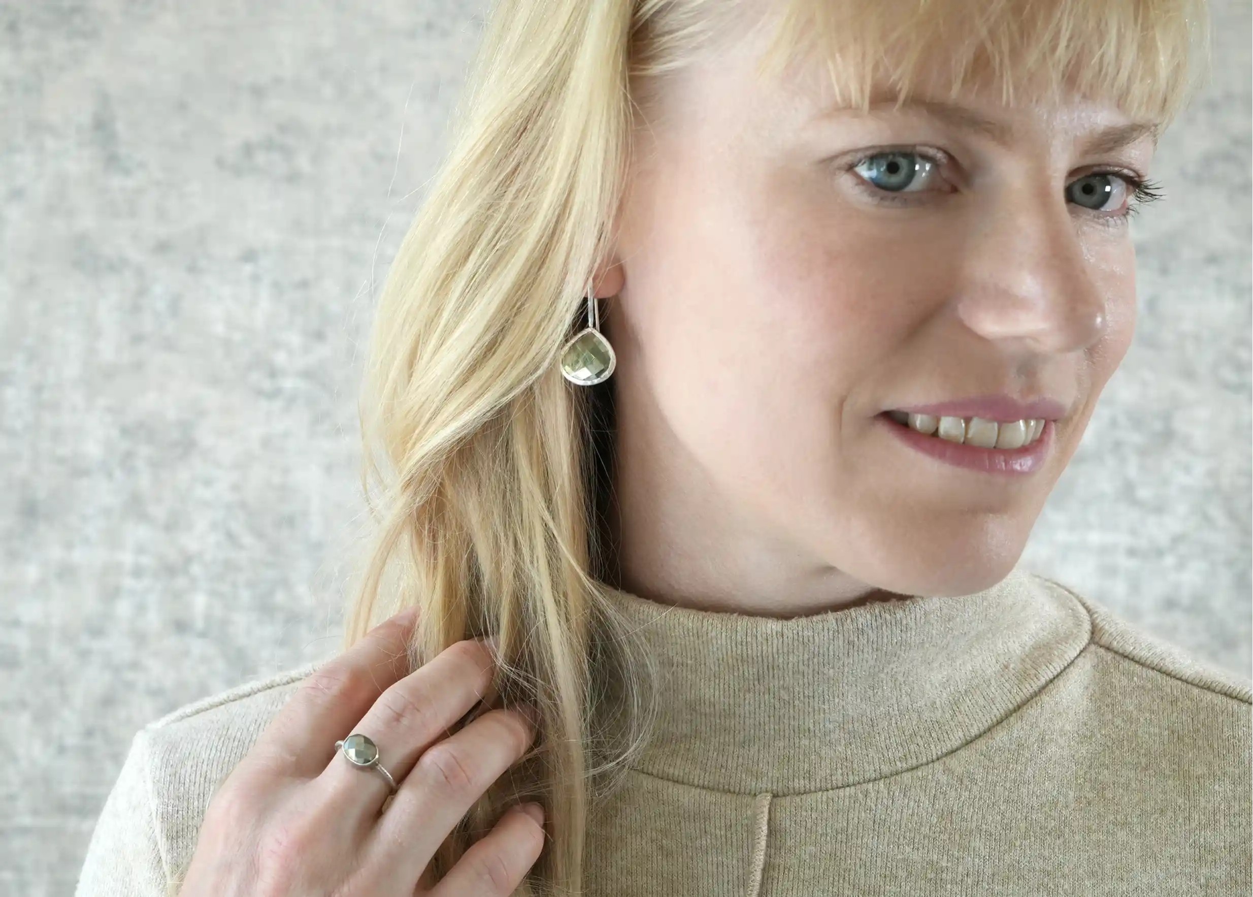 Femme portant des boucles d’oreilles « Drop » argent & pierre pyrite, collection Yamuna