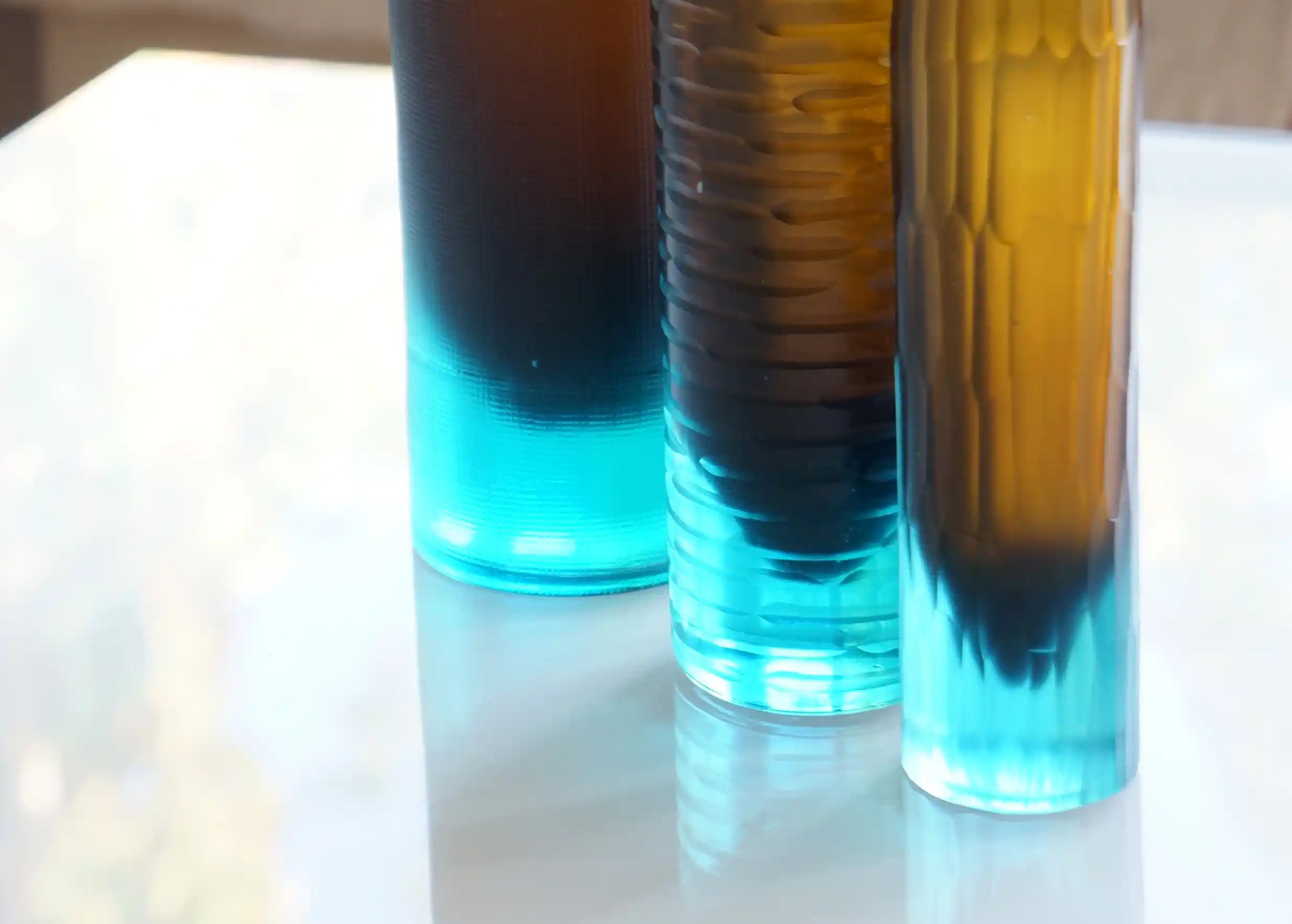 Zoom sur la base du  vase bicolore turquoise et ambre en verre recyclé, soufflé à la bouche, collection Flower