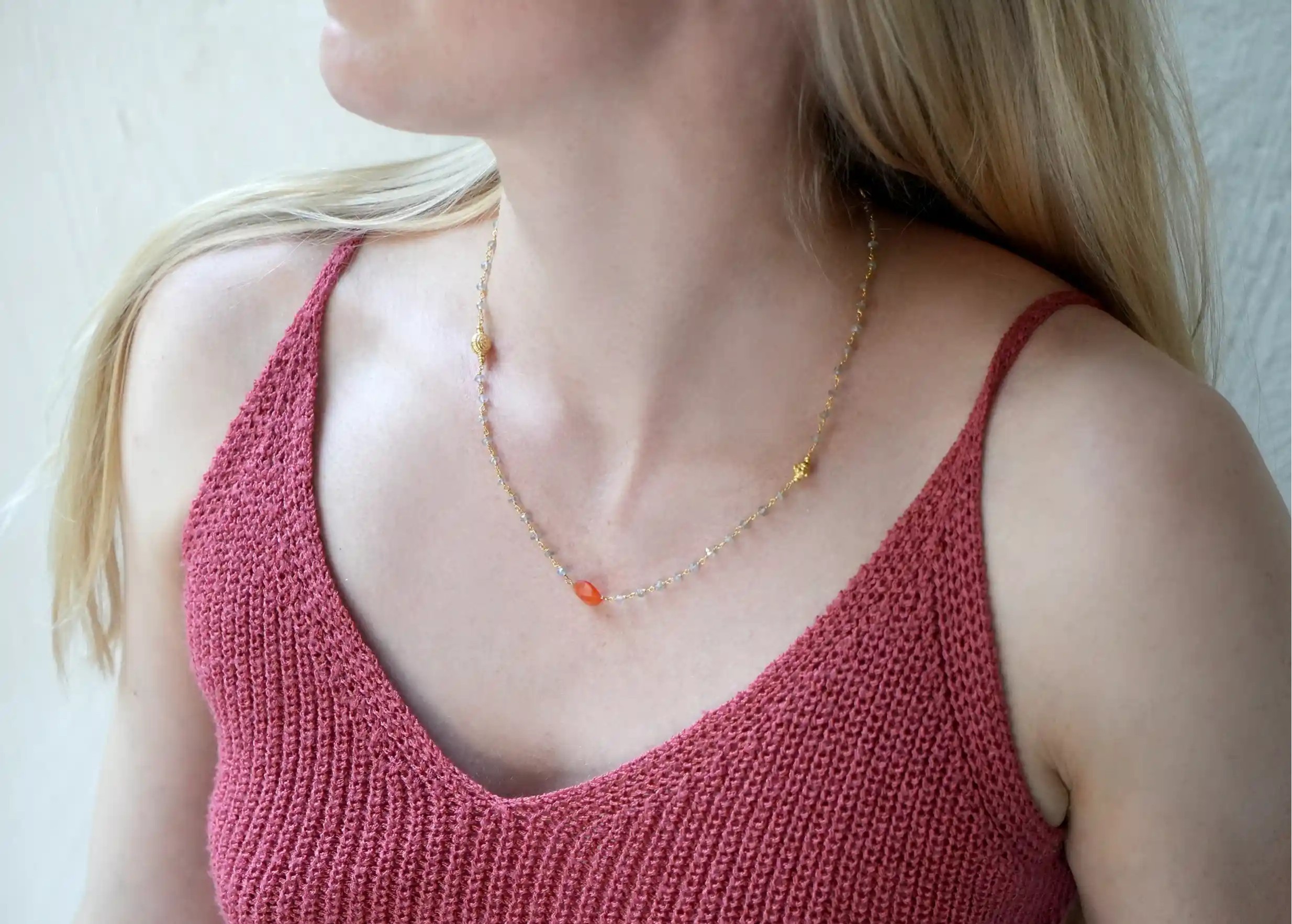 ‘Ani’ gold plated necklace with carnelian and labradorite stones, worn by a woman