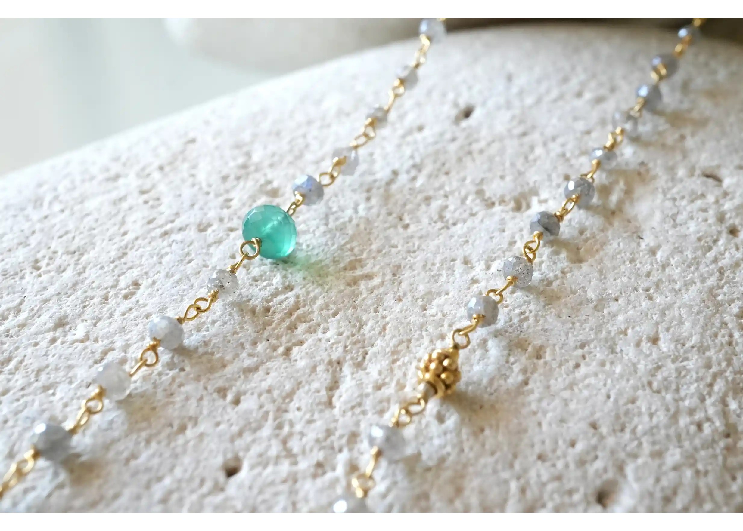 Zoom in on the details of the ‘Ani’ gold-plated necklace with green onyx and labradorite stones, from the Yamuna collection.
