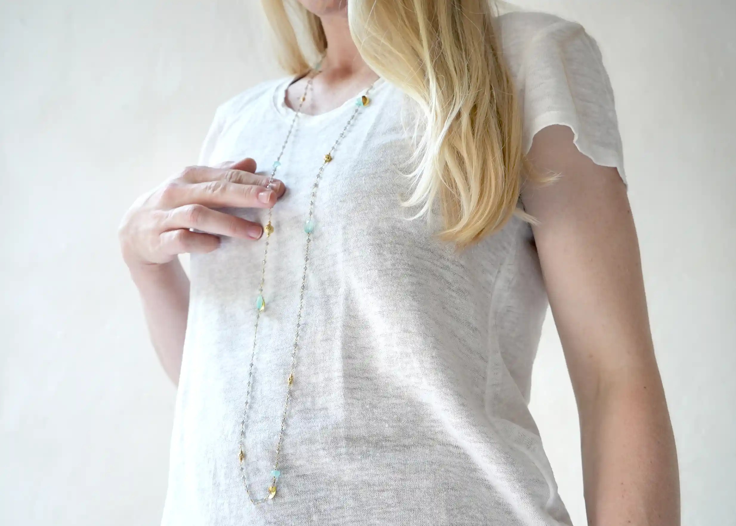 Femme portant un sautoir « Ani » Or & pierres de calcédoine et labradorite, collection Yamuna