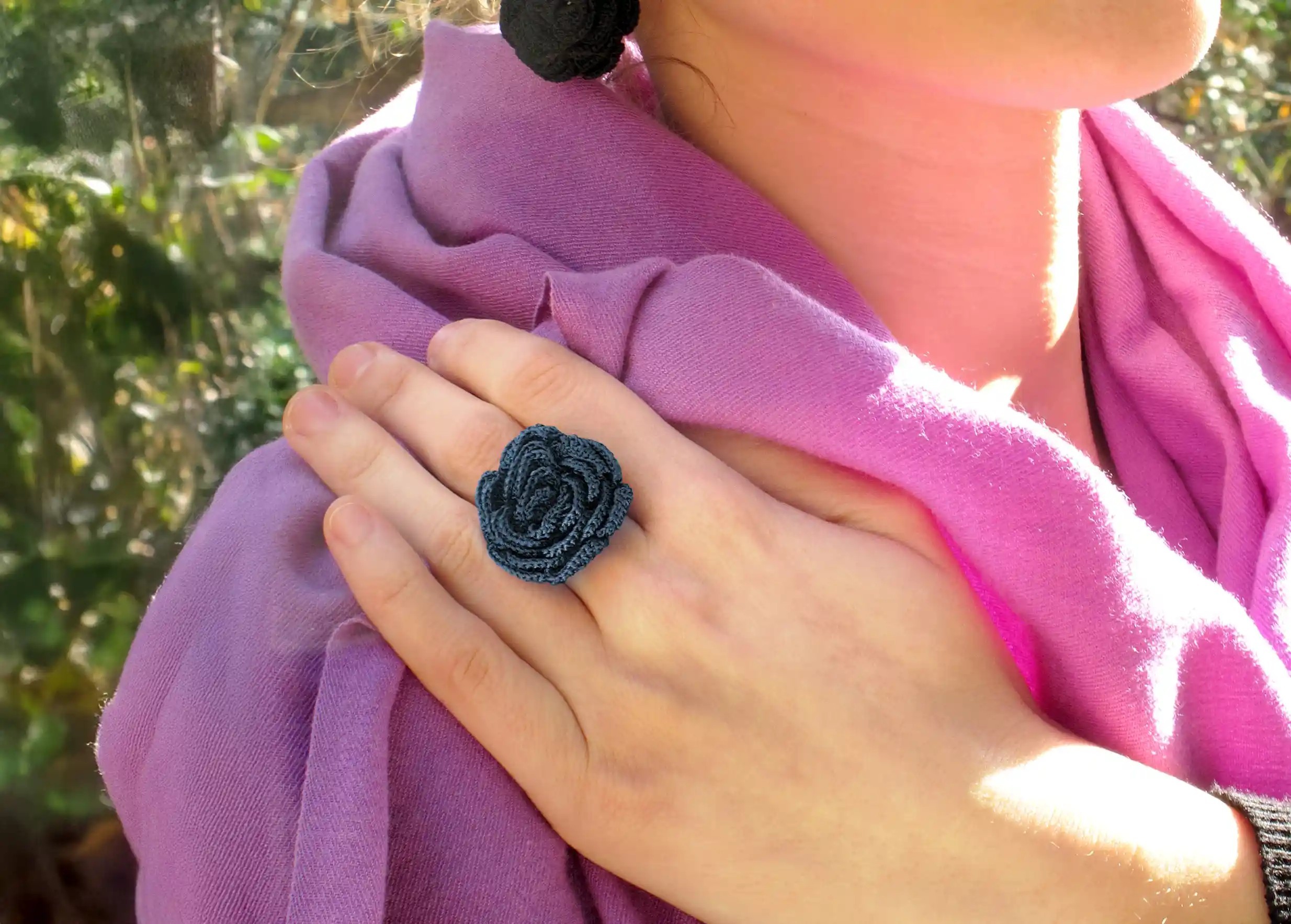 Femme en extérieur portant une bague en dentelle Belkis couleur bleu nuit