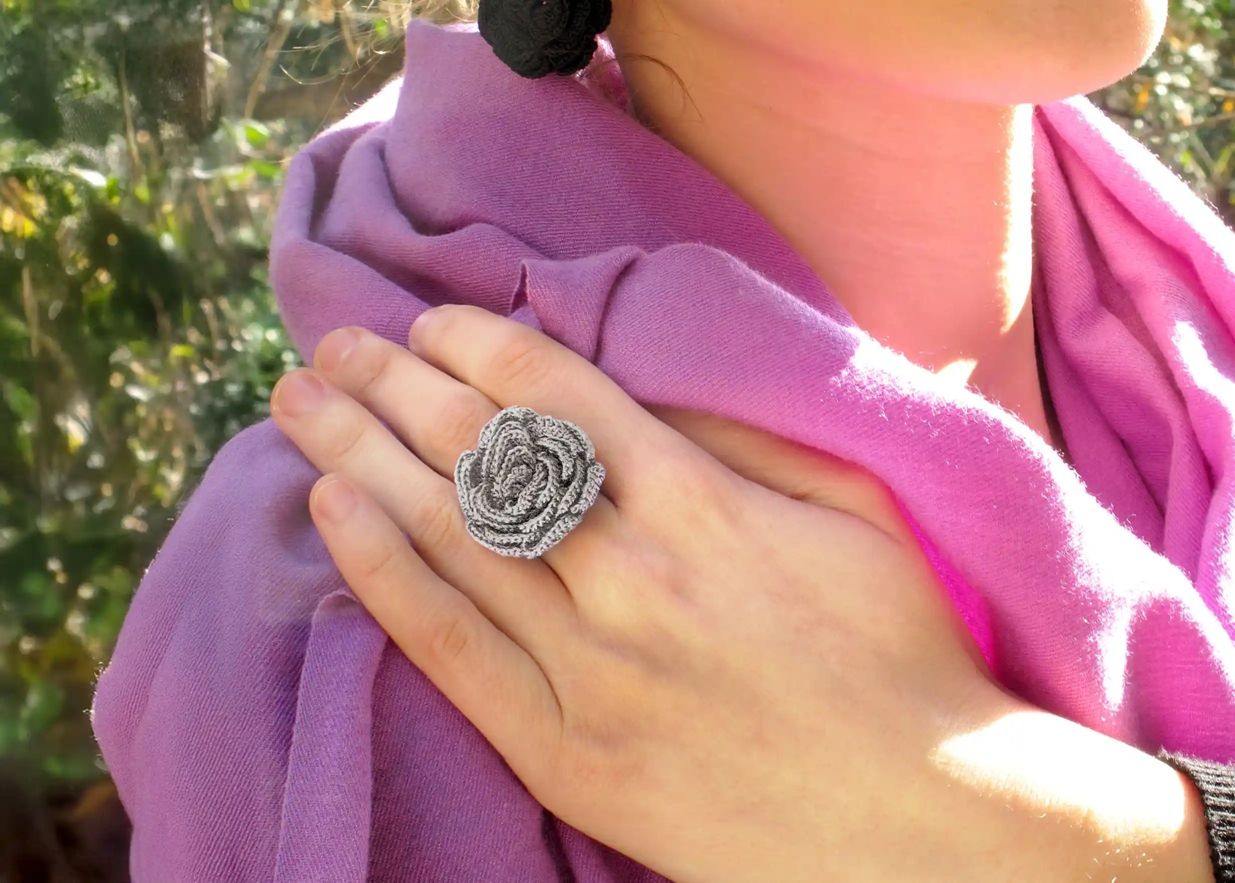 Woman wearing a Beklis lace ring in cloud grey with a twisted floral design