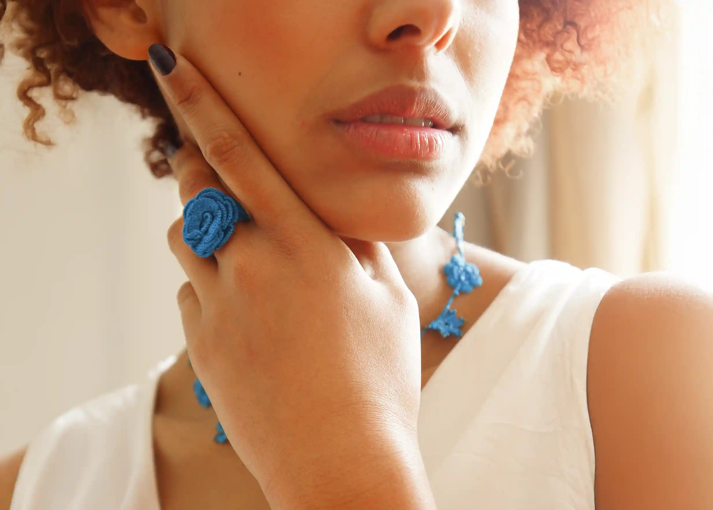 Bague en dentelle coloris Indigo électrique par Karawan, portée au doigt par une femme