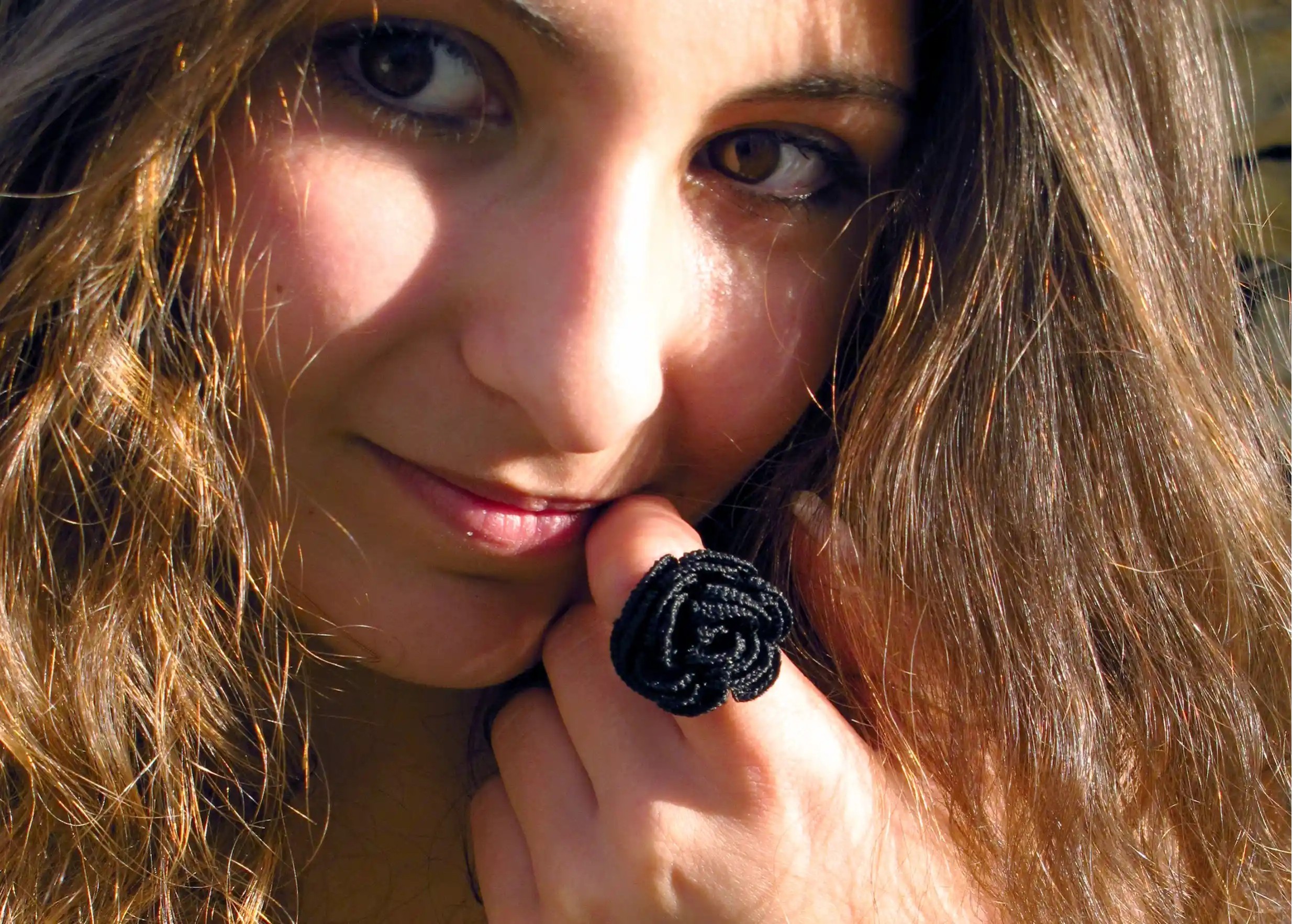 Femme en extérieur portant une bague en dentelle Beklis couleur noir carbone au design floral torsadé