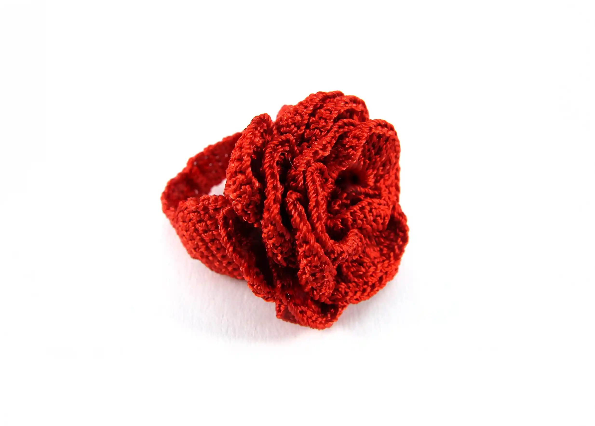Side view of the floral design on a red lace ring, cut-out background