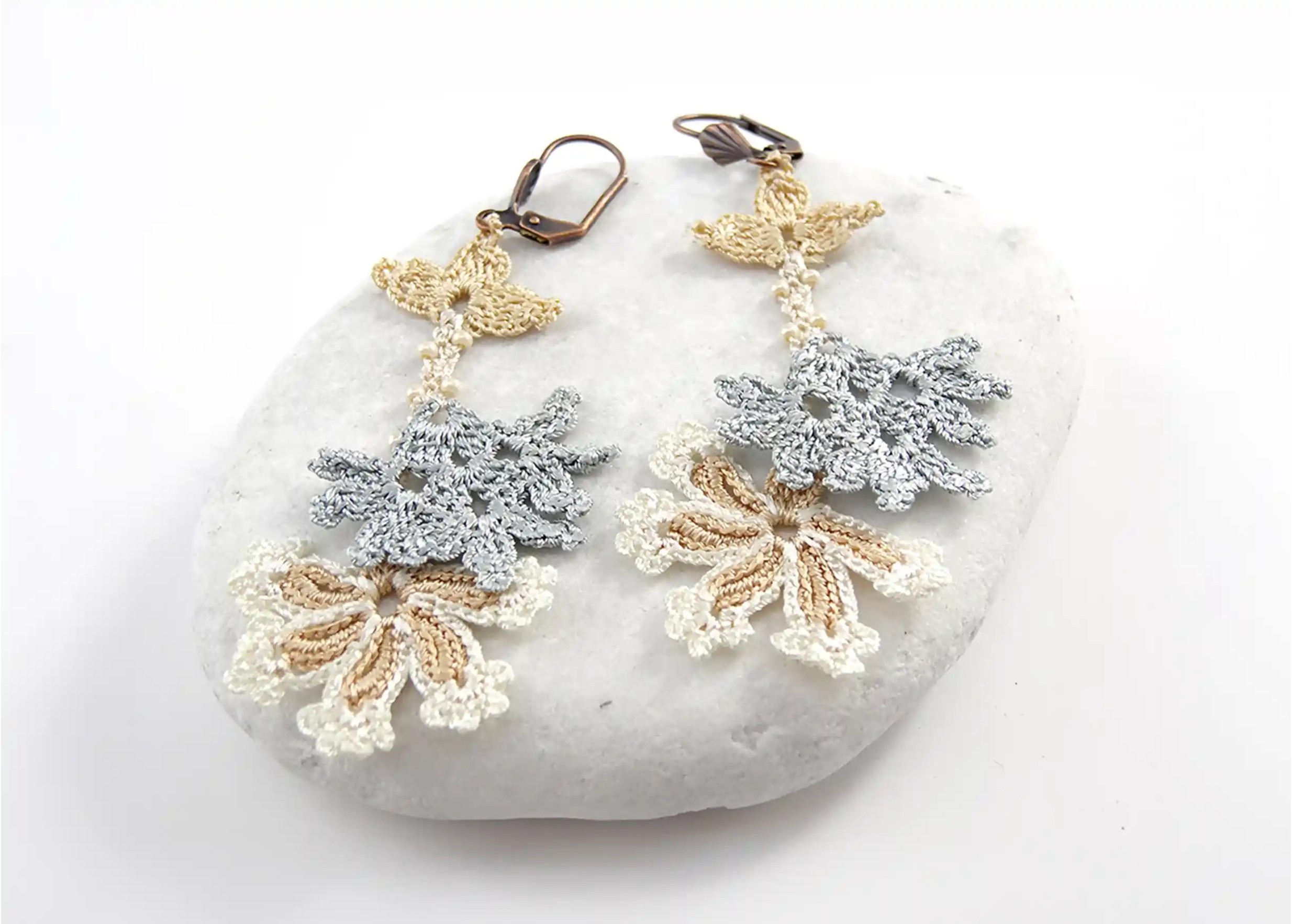 Boucles d'oreilles en dentelle Kapadokya, modèle double winter sur fond blanc posé sur une pierre