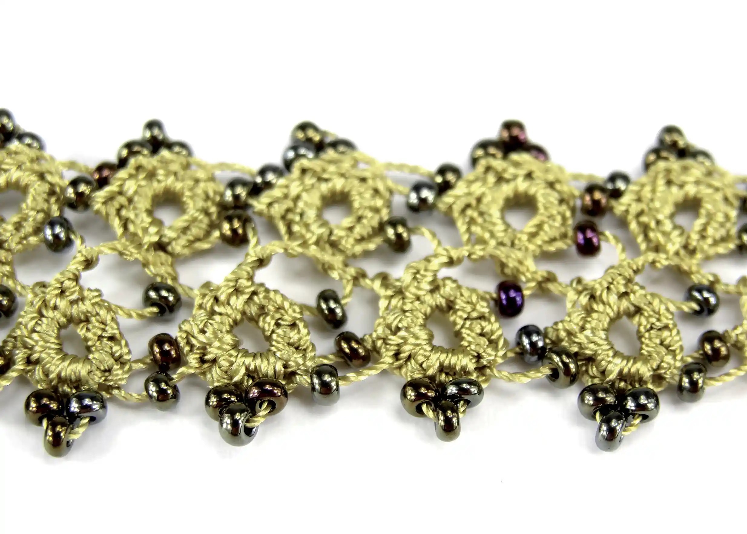 Zoom sur les perles foncées d'un bracelet en dentelle au coloris Vert lichen