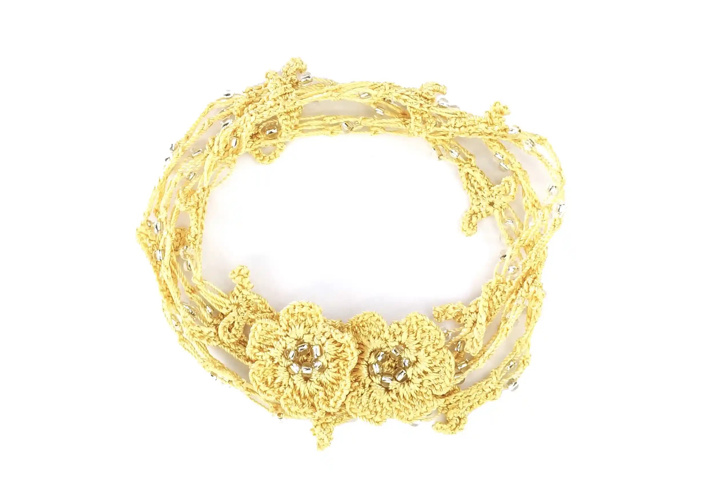 Bracelet-collier chaînette en dentelle vanille, délicatement enroulé sur fond blanc