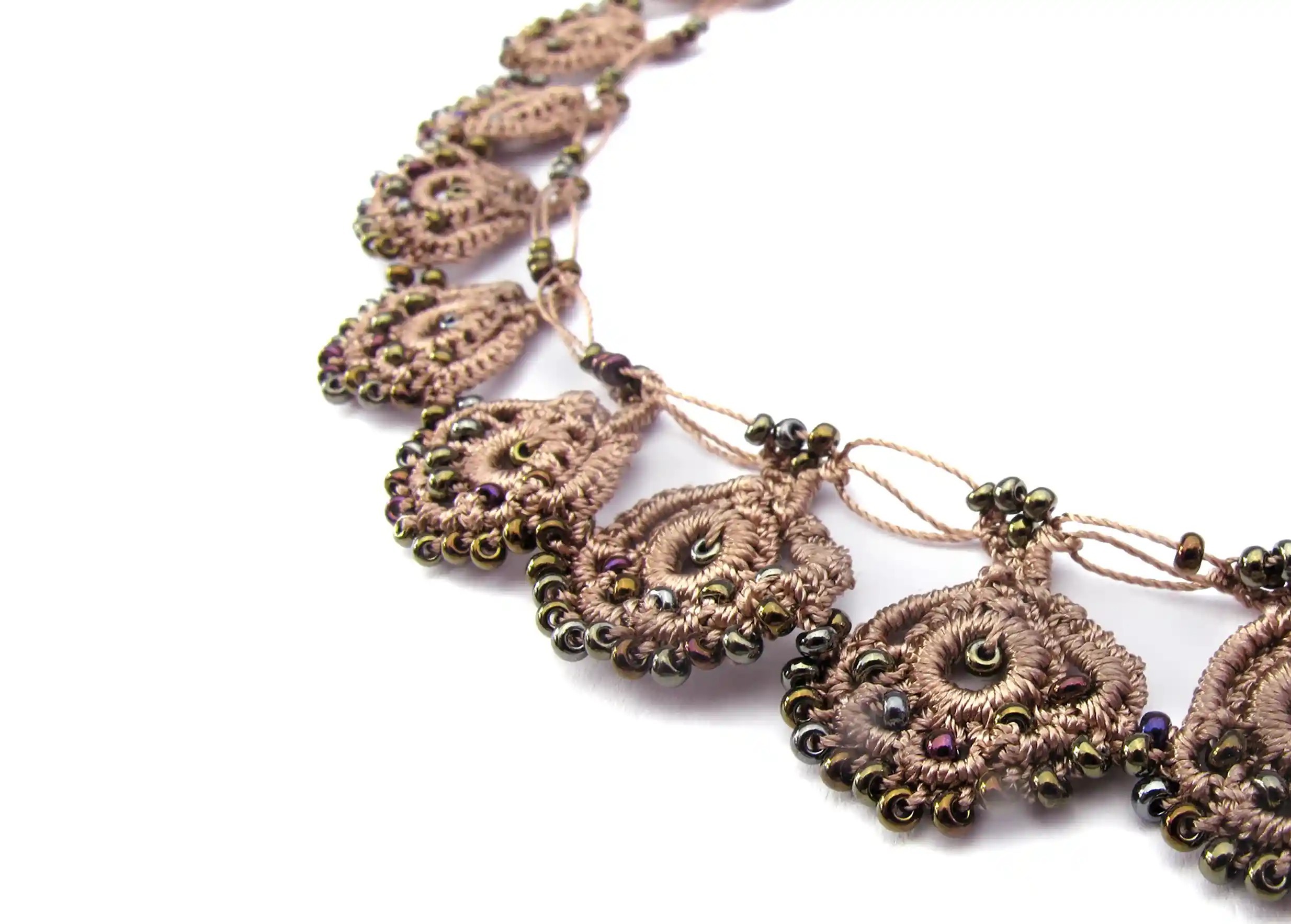 Zoom sur le collier en dentelle Eda sable doré avec des motifs ornés de perles scintillantes