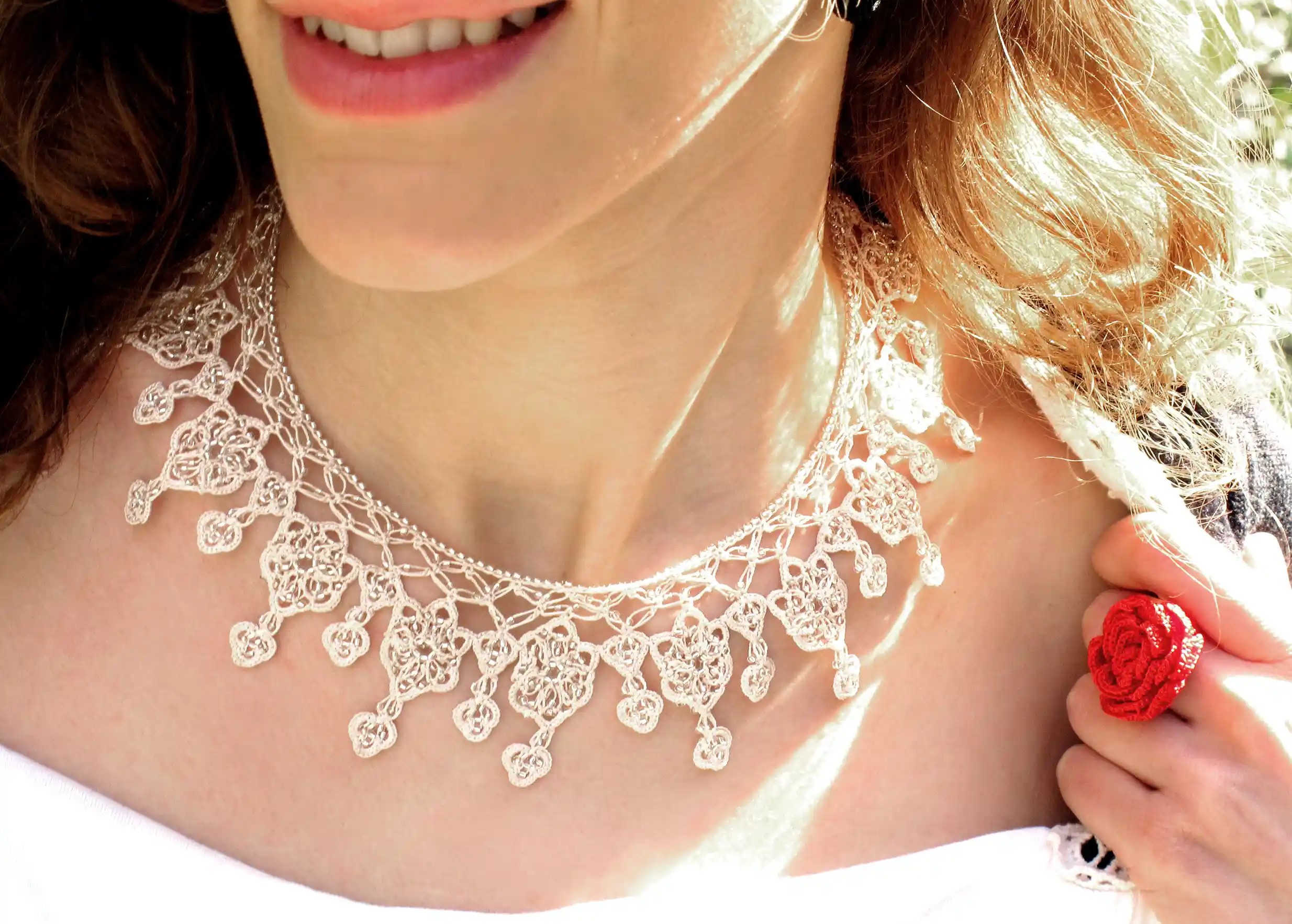 Collier en dentelle Sonya coloris ivoire, porté sur une tenue blanche dans un cadre lumineux