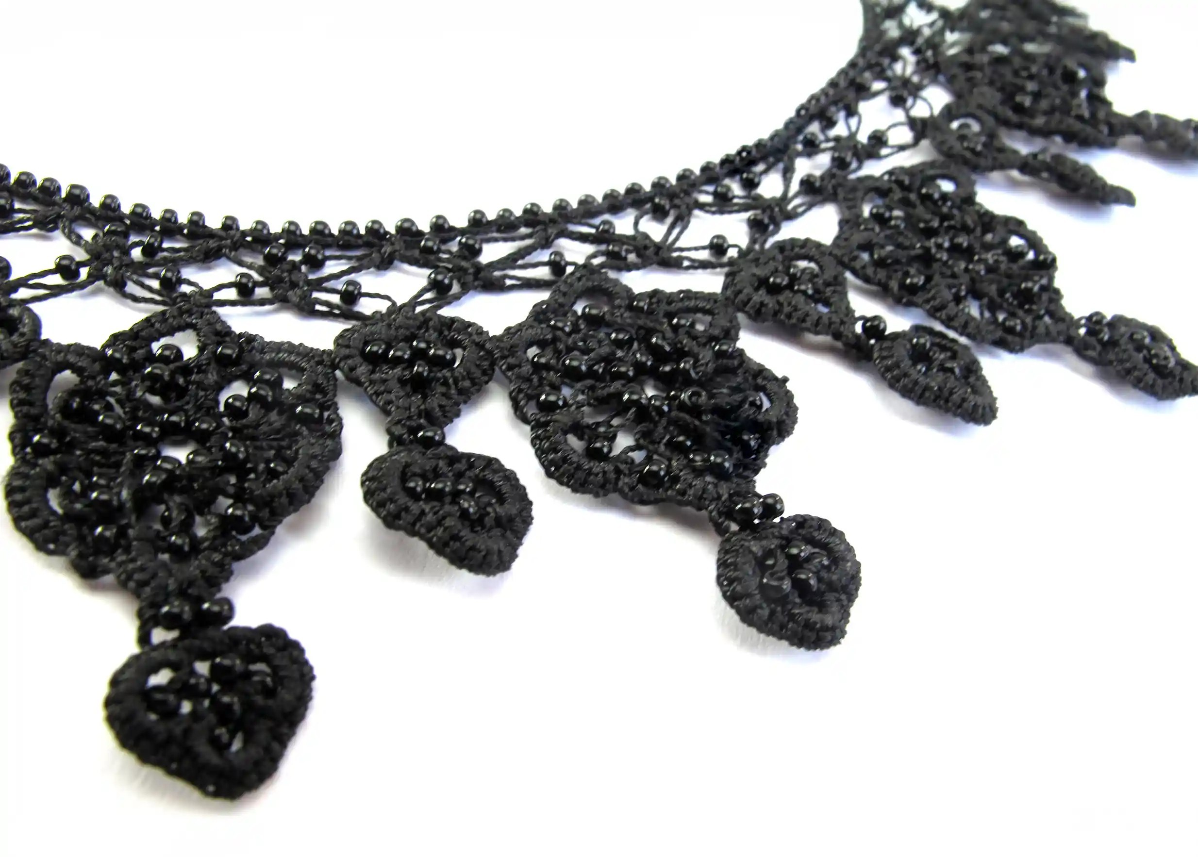 Focus sur les motifs du collier Sonya noir carbone, tissés à la main en dentelle