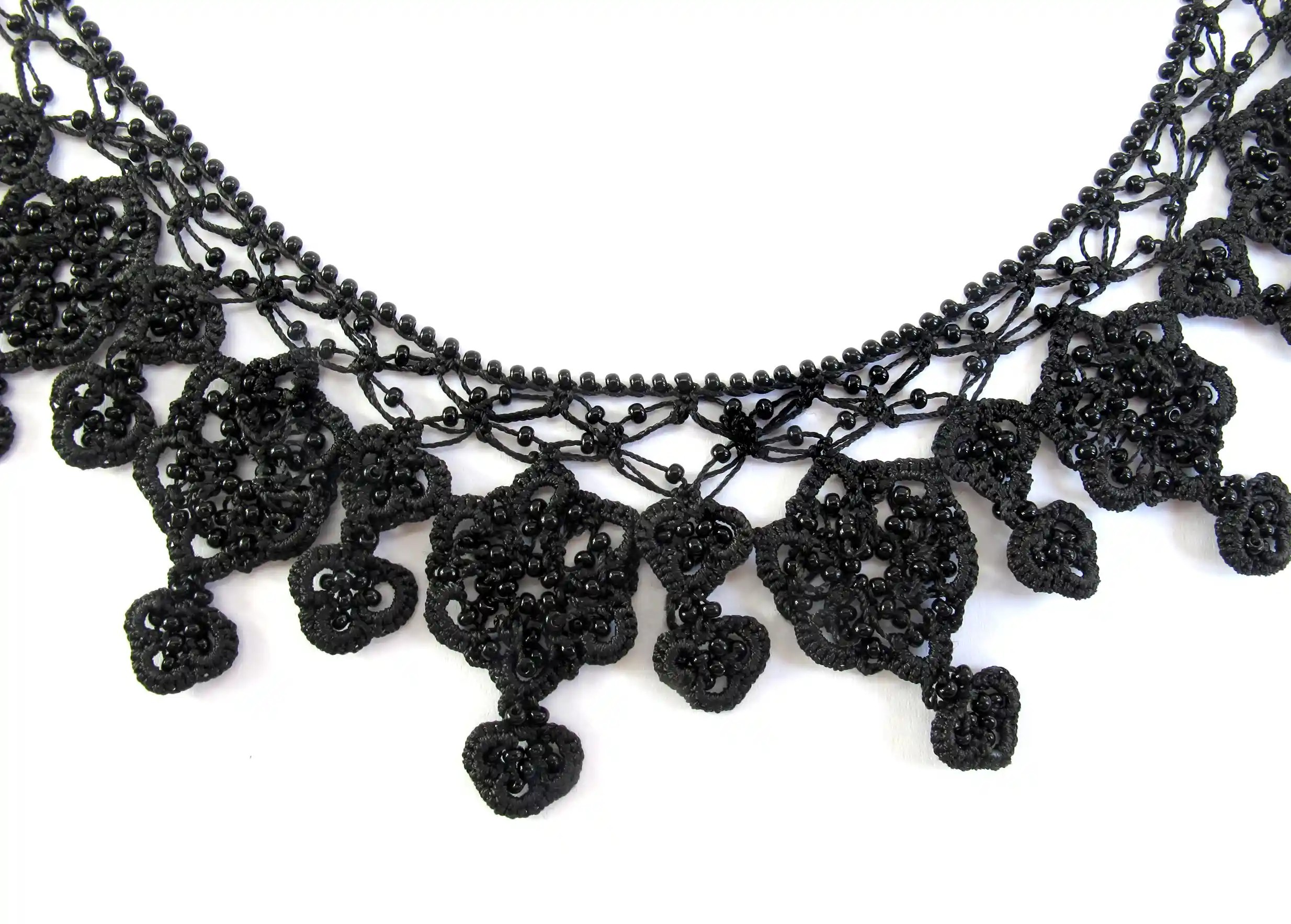 Gros plan sur les motifs du collier Sonya noir carbone, tissés à la main en dentelle