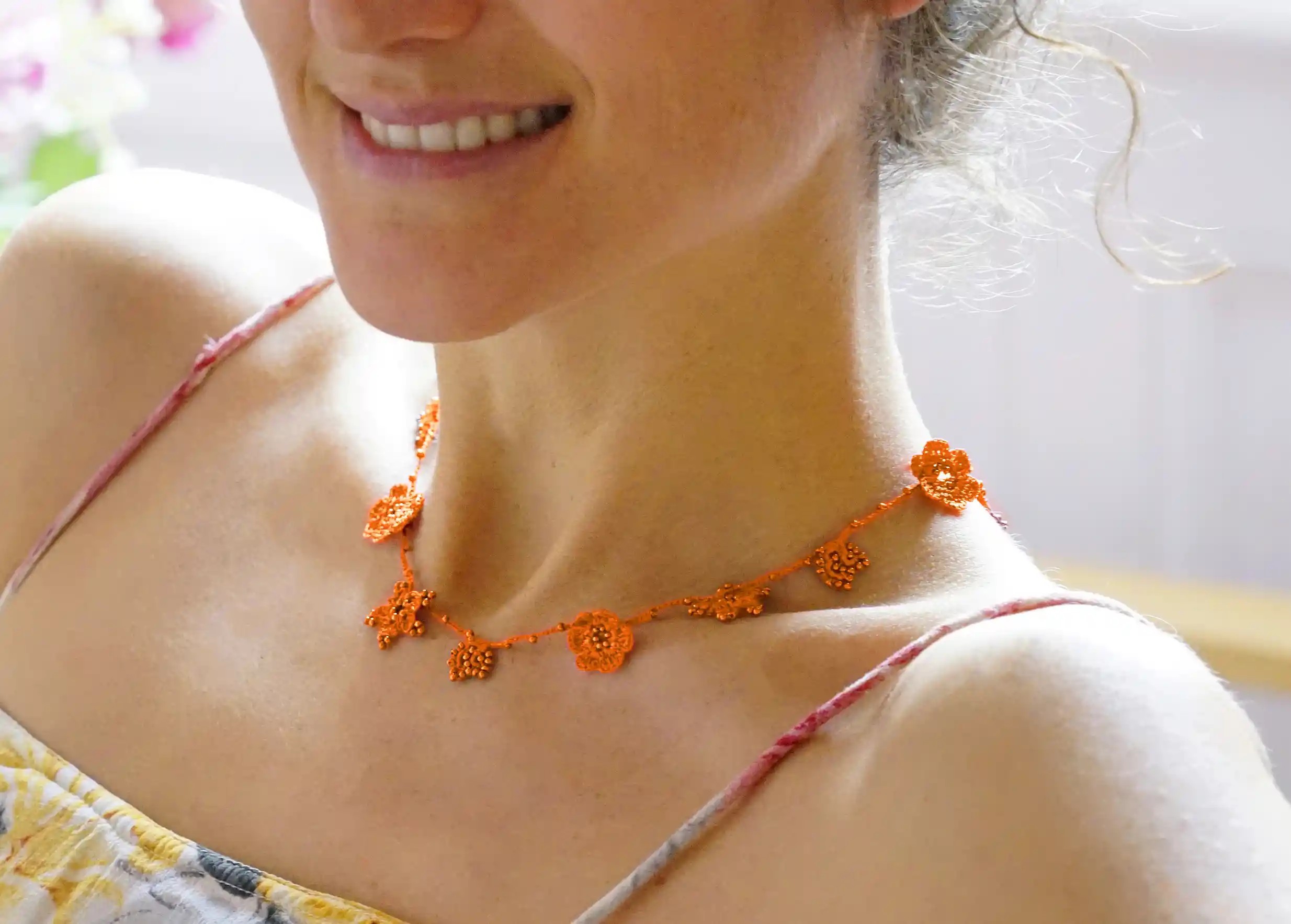 Papaya-coloured Crystal lace choker worn by a woman indoors