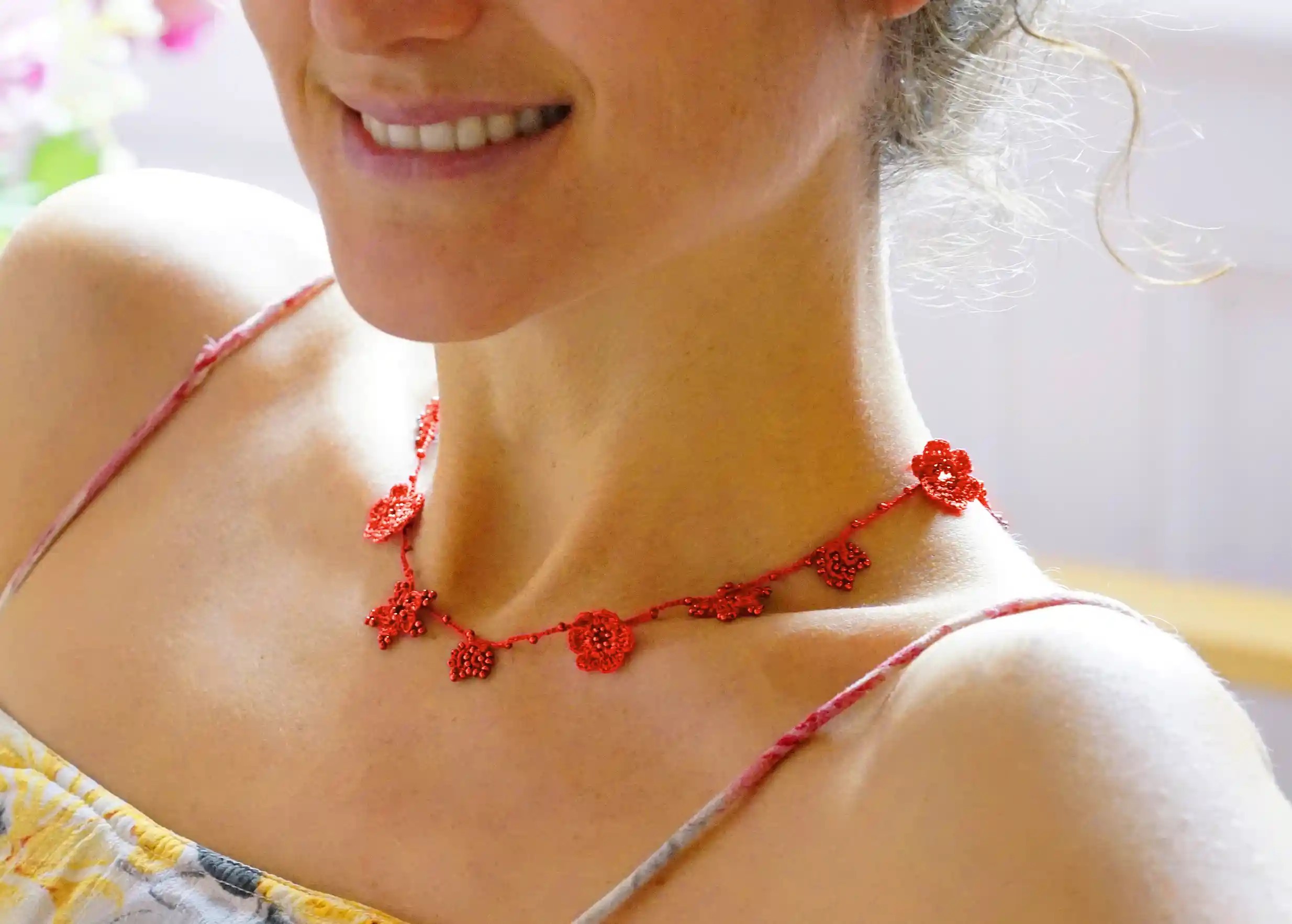 Red crystal lace choker worn by a woman indoors