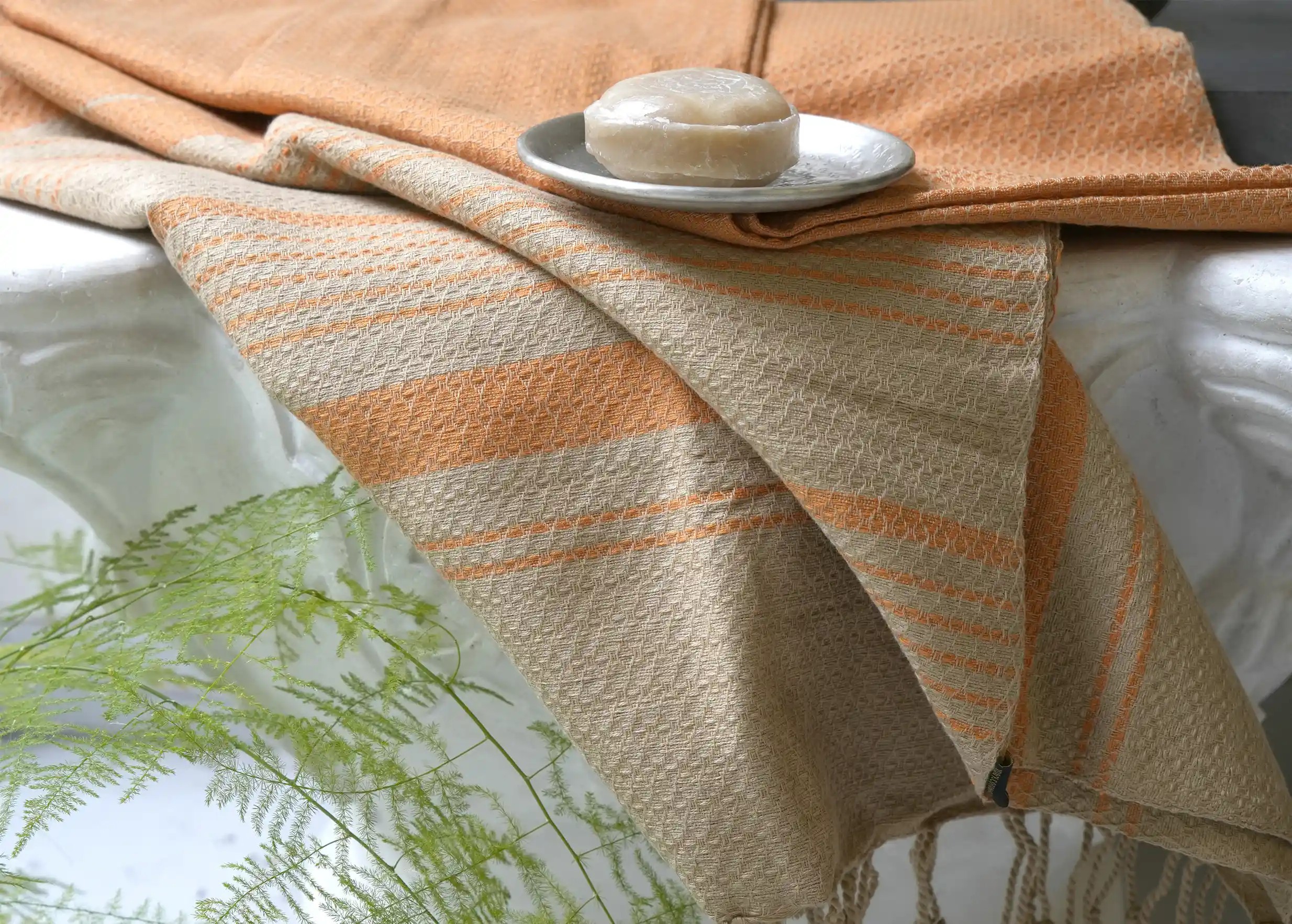 Karawan Authentic organic cotton fouta towel, turmeric colour, with Ayurvedic soap on top