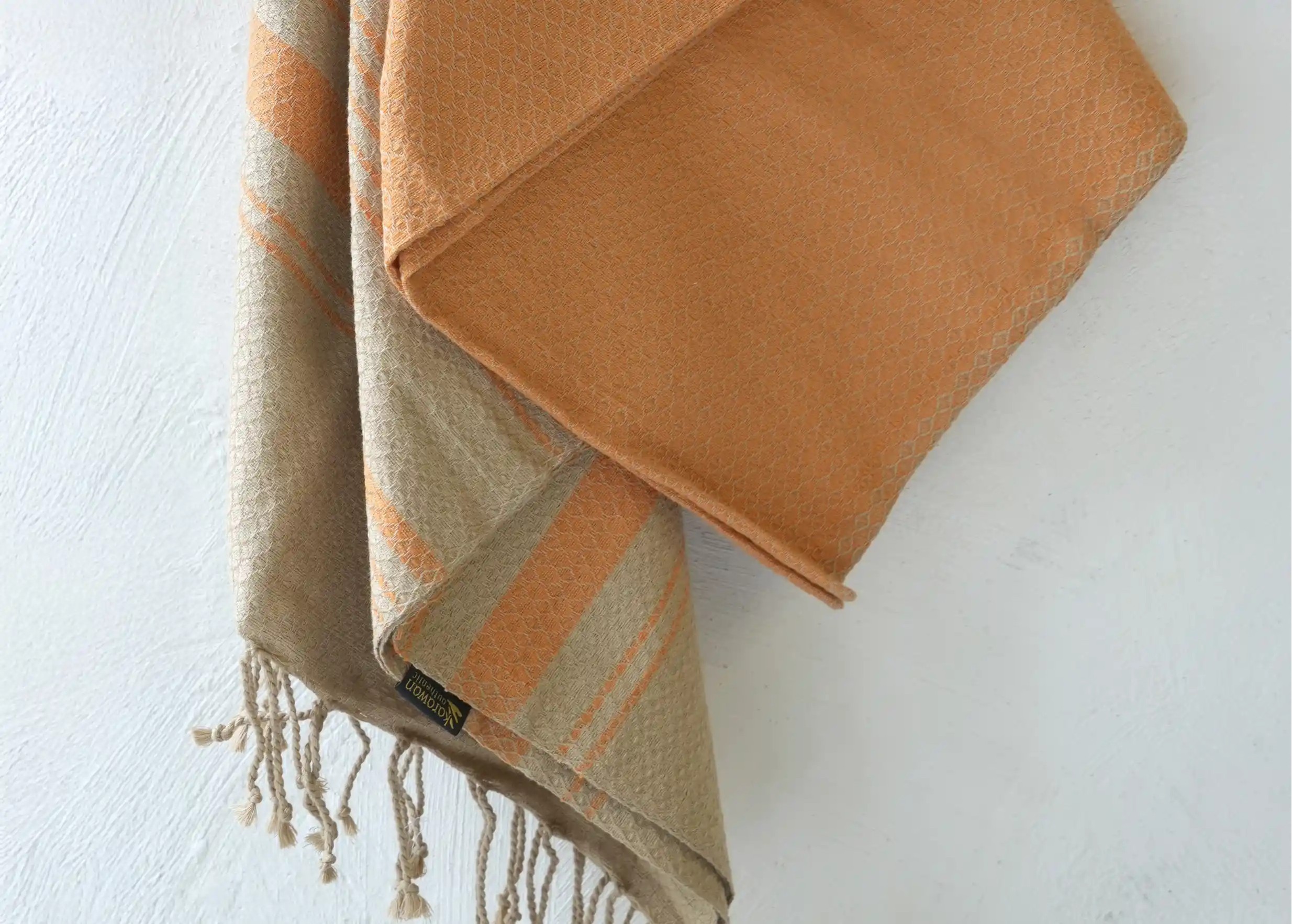 Close-up on the details of the weave and fringes of the turmeric-coloured fouta by Karawan Authentic.