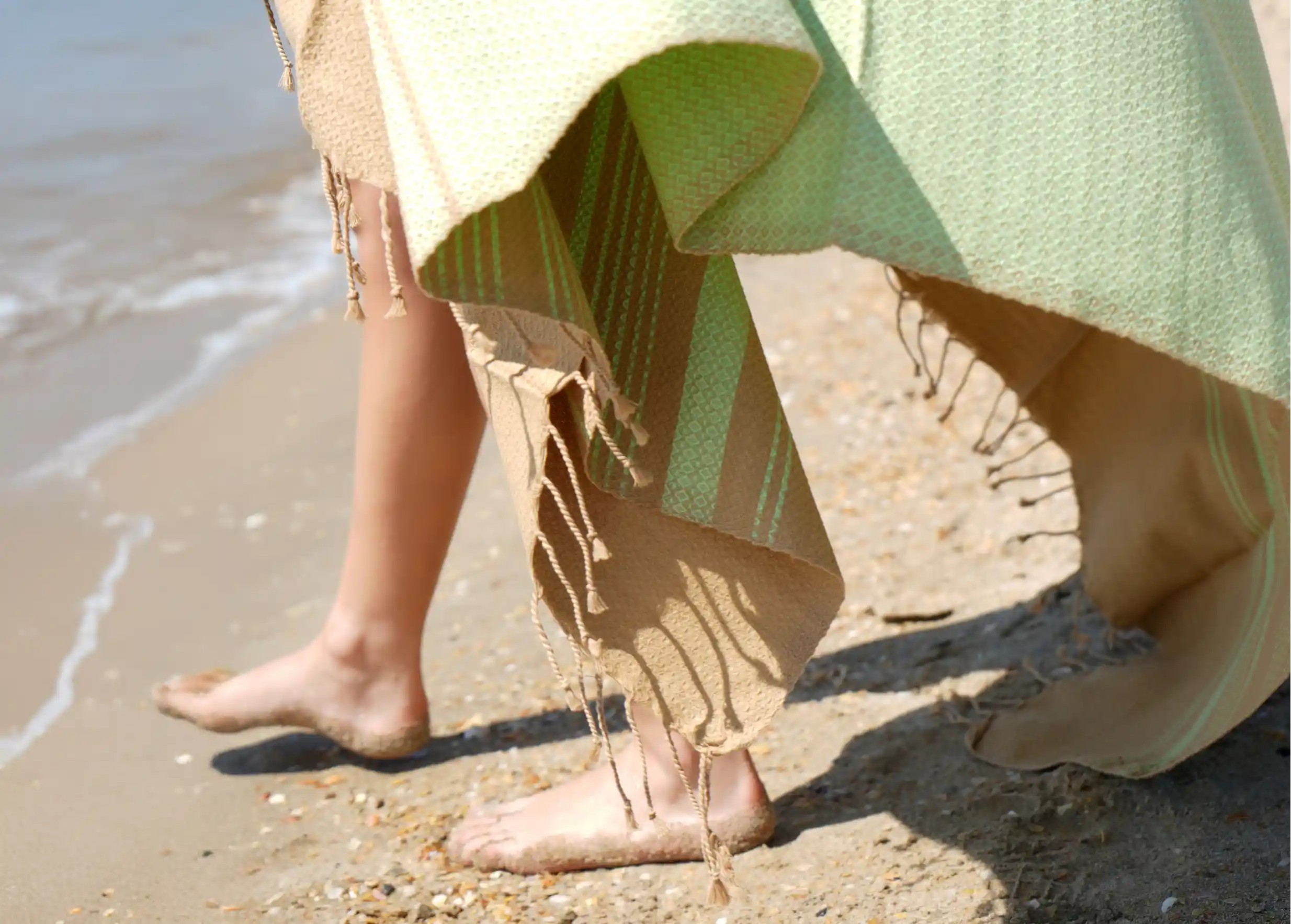 Close-up on the details of the weave and fringes of the pistachio-coloured fouta by Karawan Authentic.
