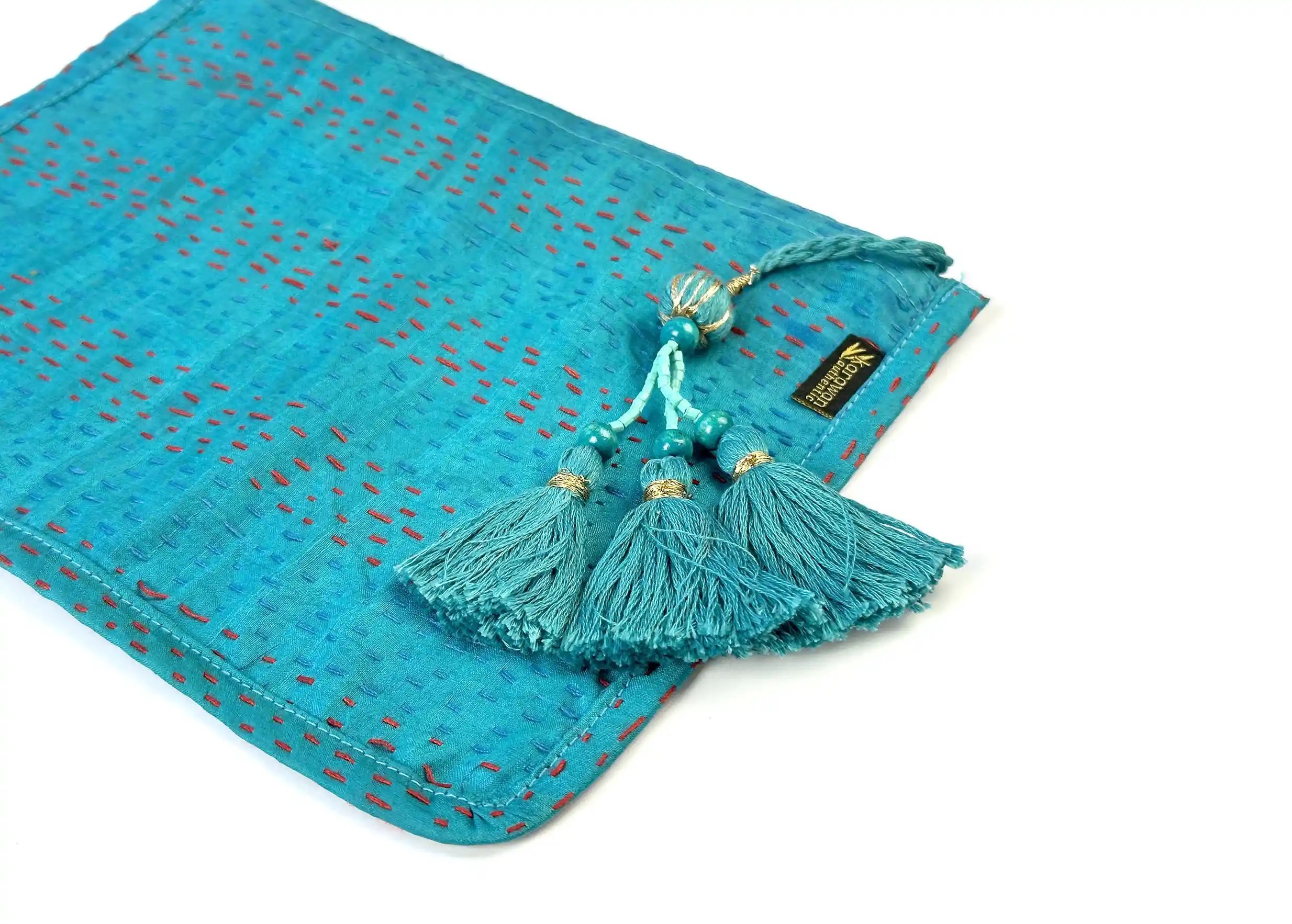 Close-up of the handmade clutch bag in recycled kanta silk, model no. 01, with tassel, from the brand Karawan Authentic