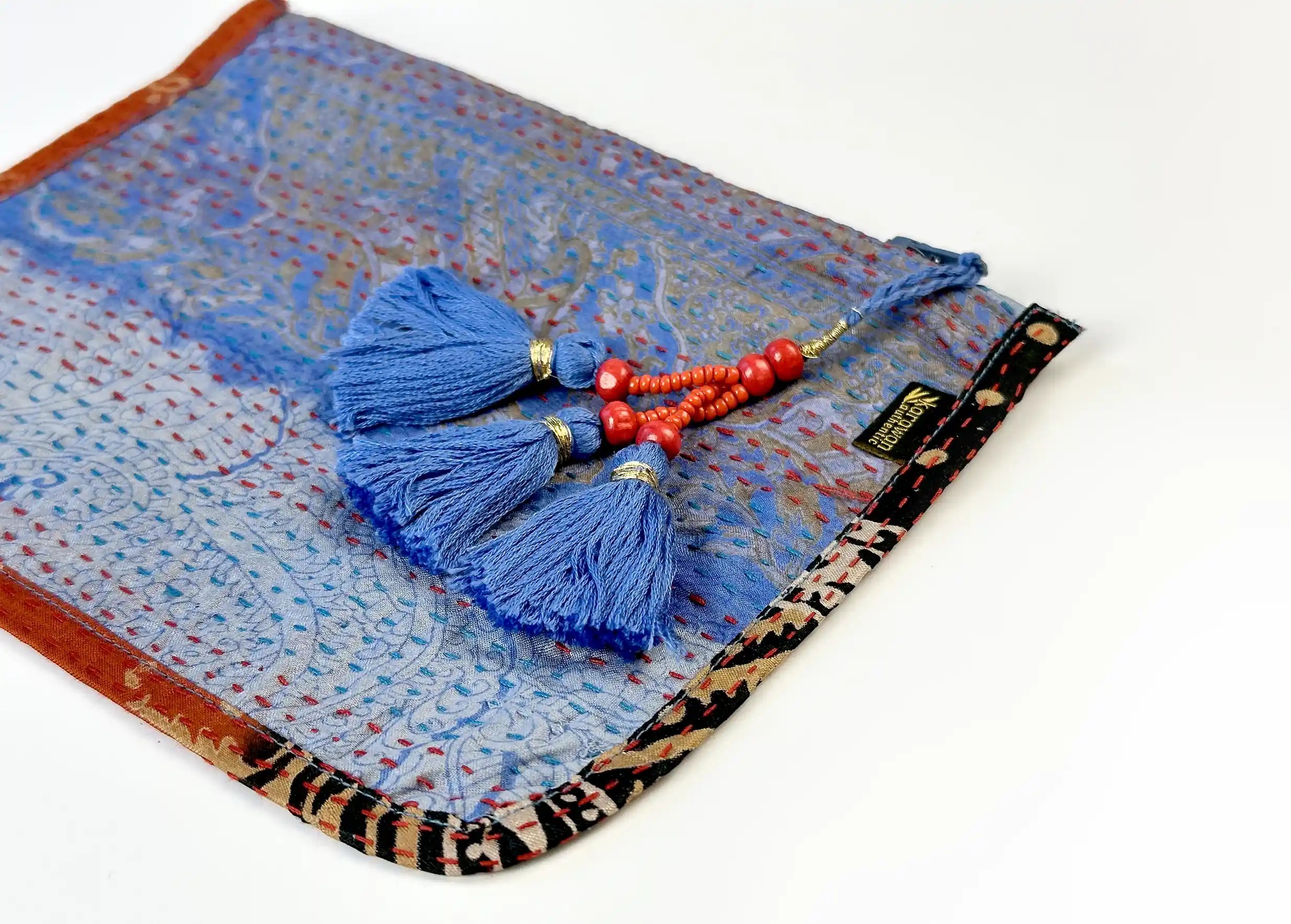 Focus on the pompom and patterns of the handmade recycled kanta silk clutch bag, model no. 03