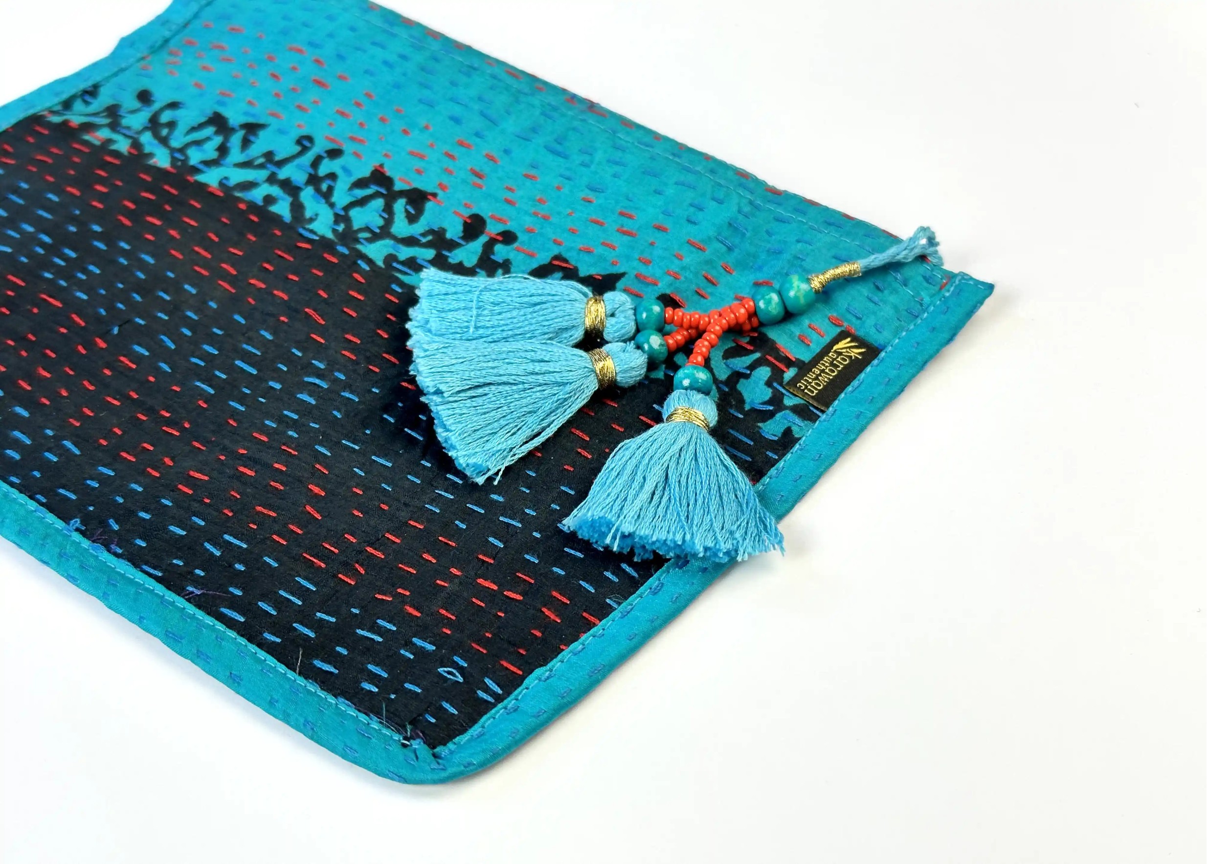 Focus on the pompom and patterns of the handmade recycled kanta silk clutch bag, model no. 09
