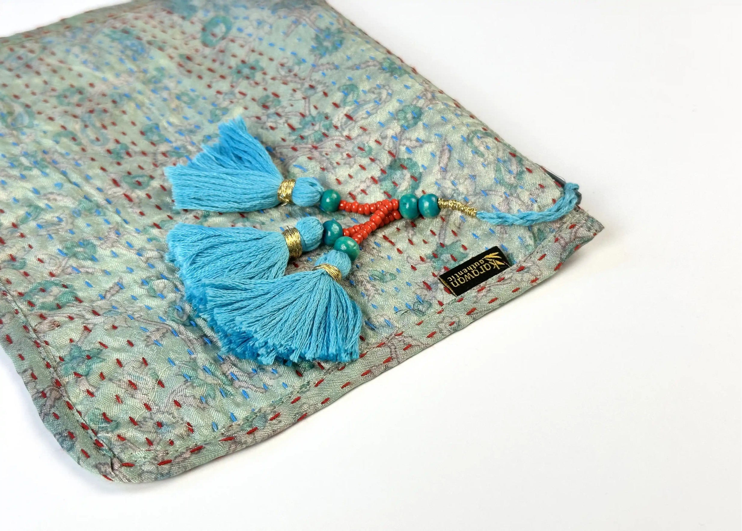 Focus on the pompom and patterns of the handmade recycled kanta silk clutch bag, model no.11