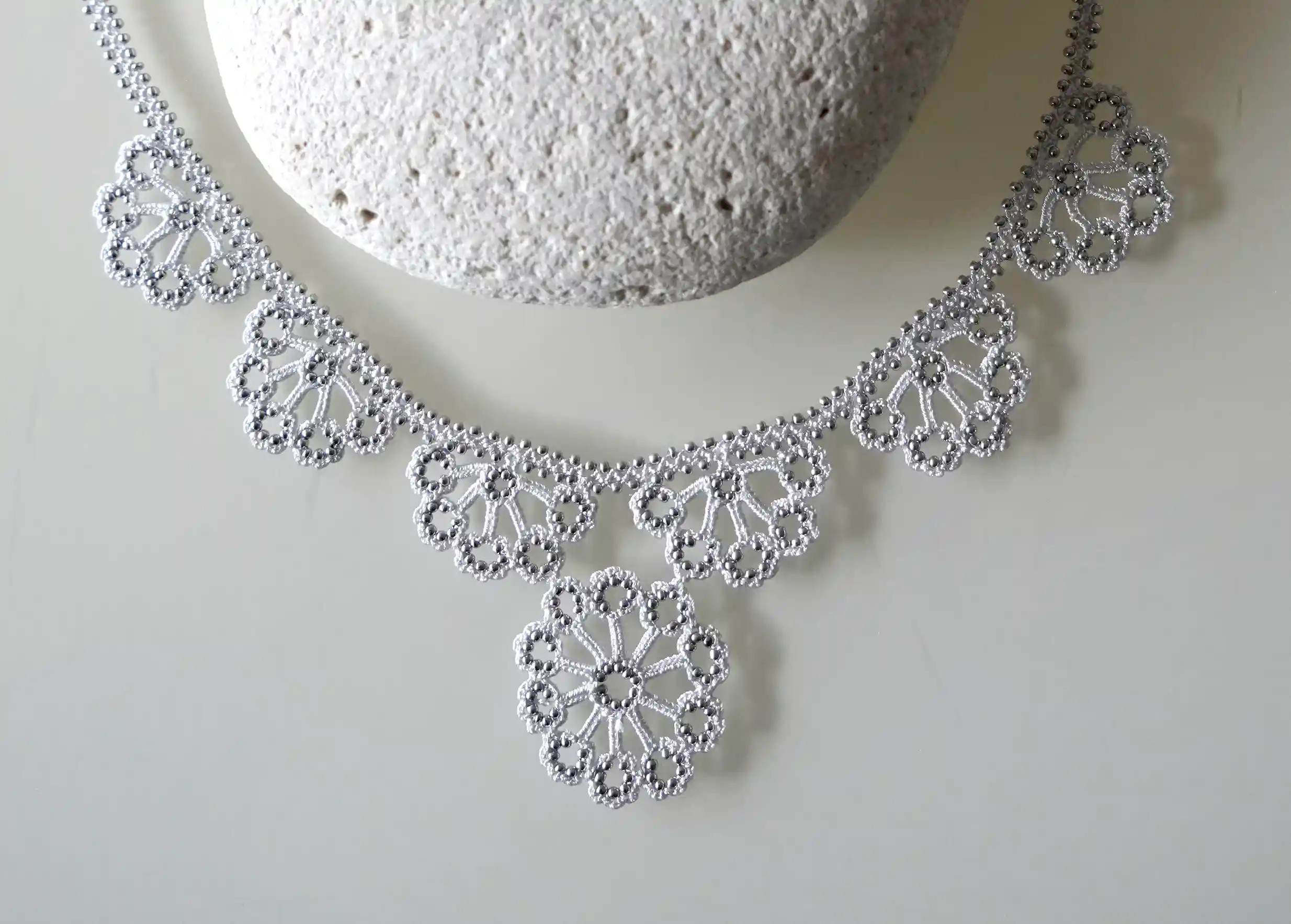 Close-up on the design of the silver grey Hawa lace necklace by Karawan