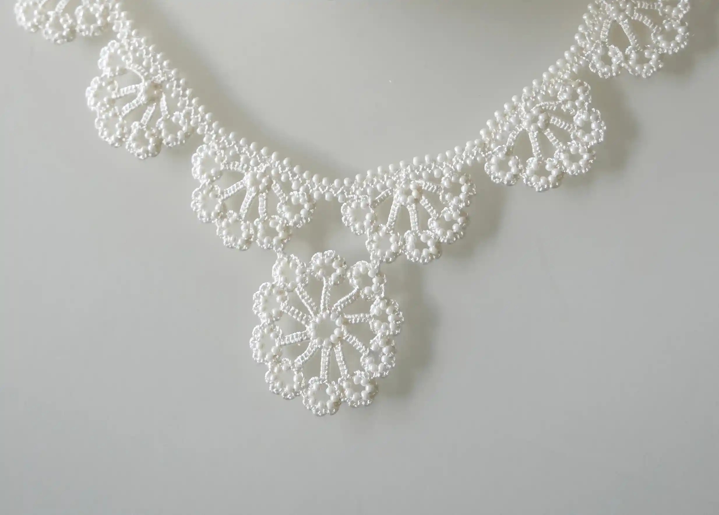 Gros plan sur le design du collier en dentelle Hawa couleur Ivoire par Karawan