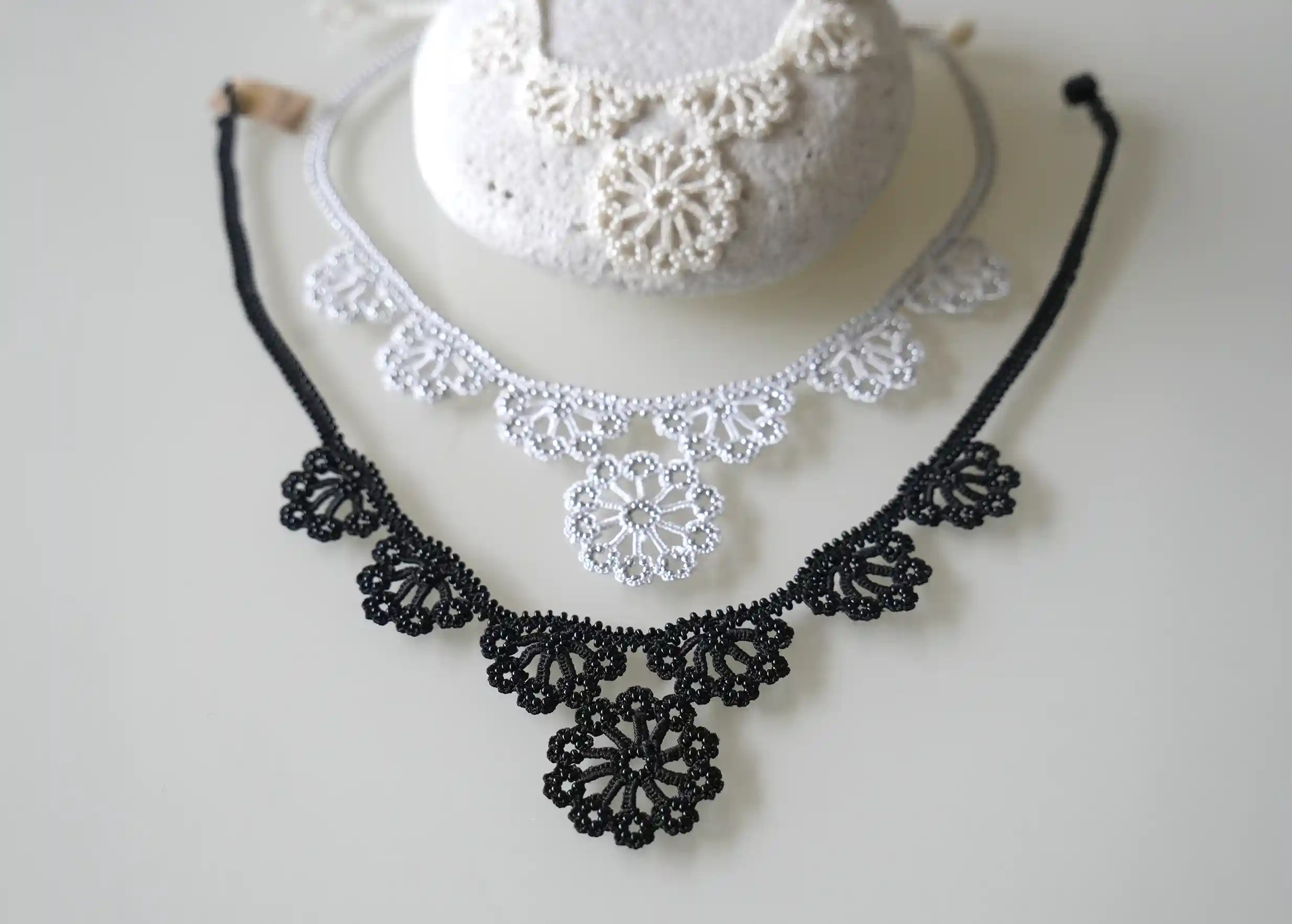 Trois colliers Hawa de la marque Karawan gris argent, noir et ivoire.