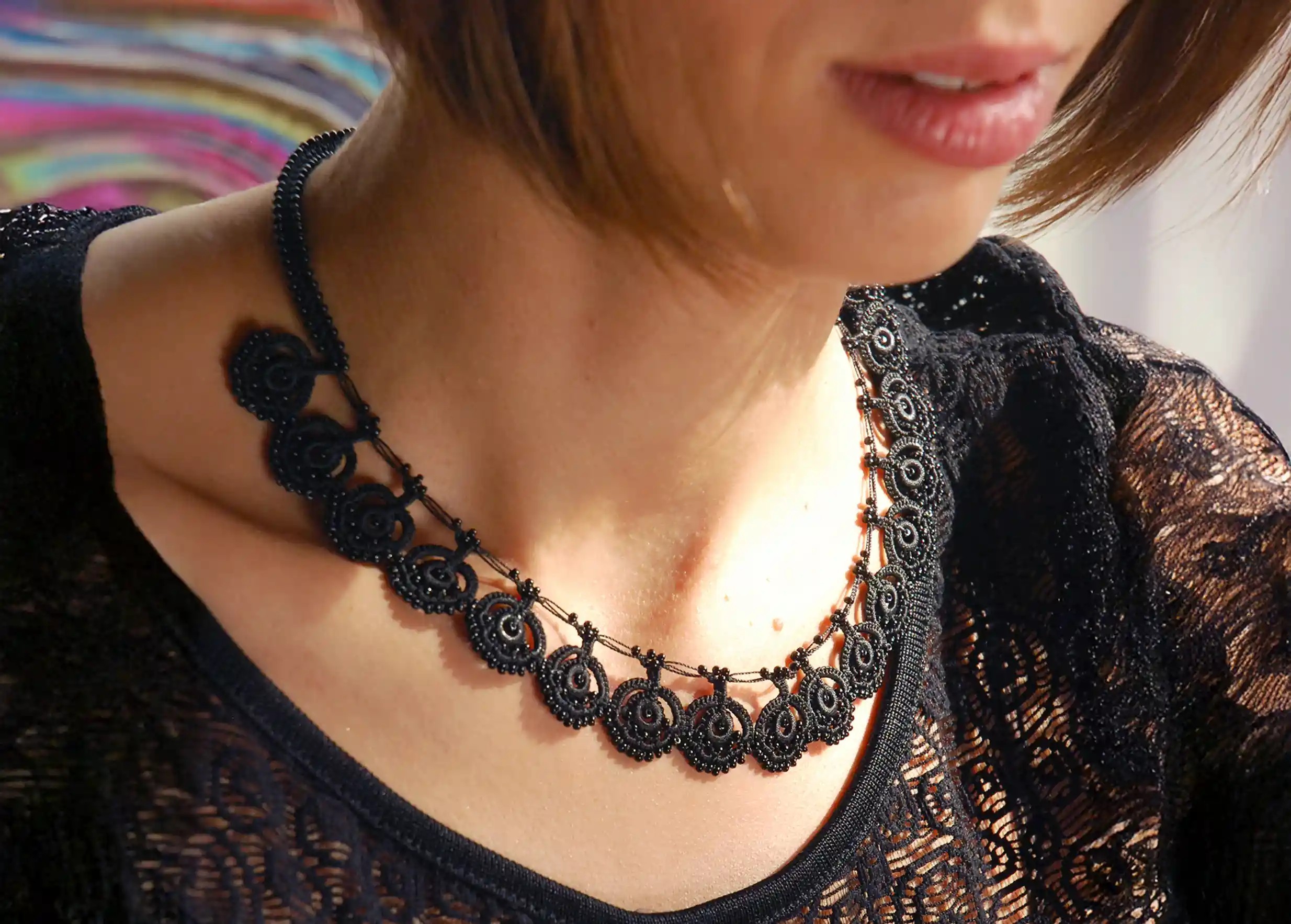 Eda lace necklace in carbon black worn around a woman's neck