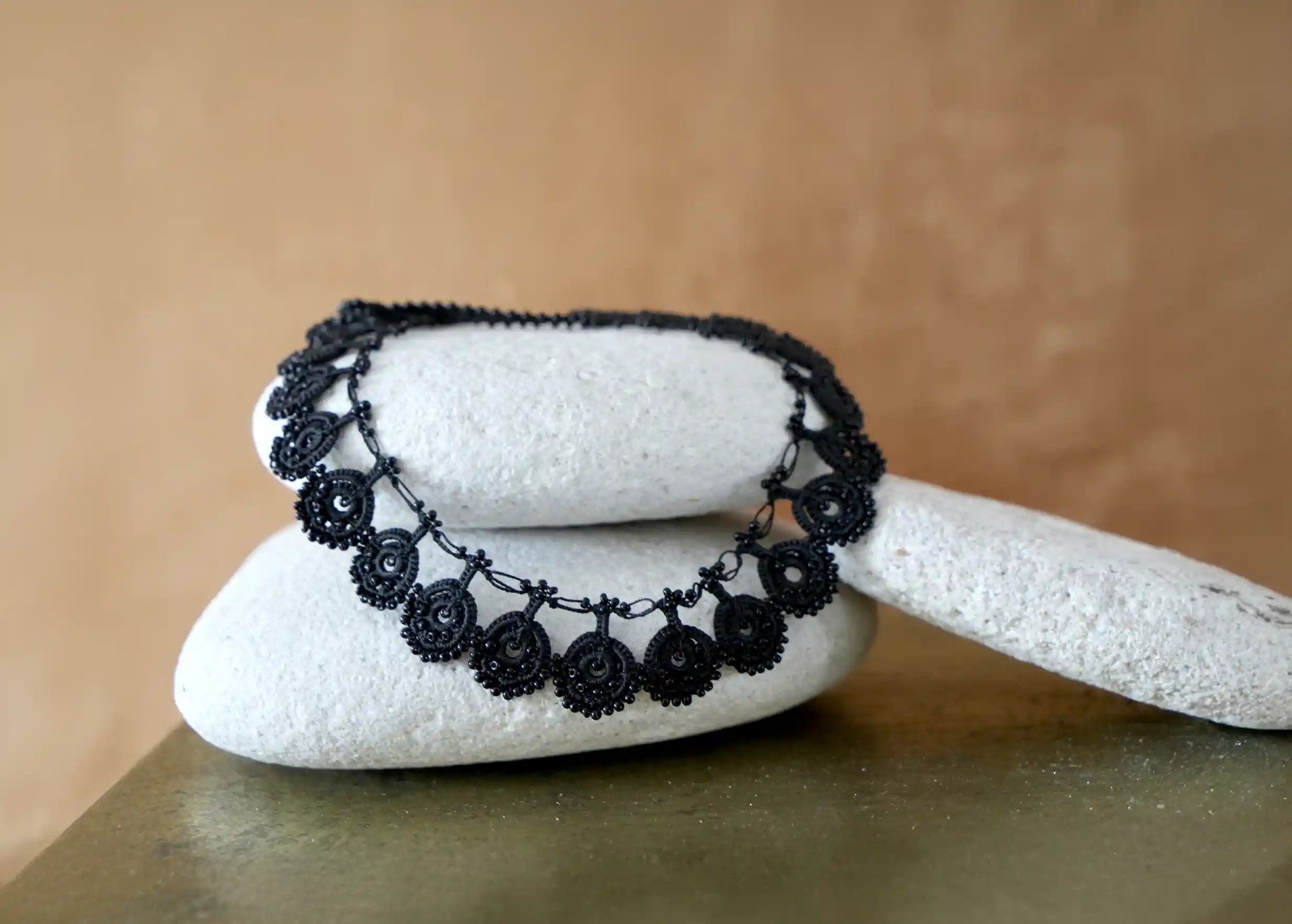 Handmade Oya lace necklace by Karawan, ochre background